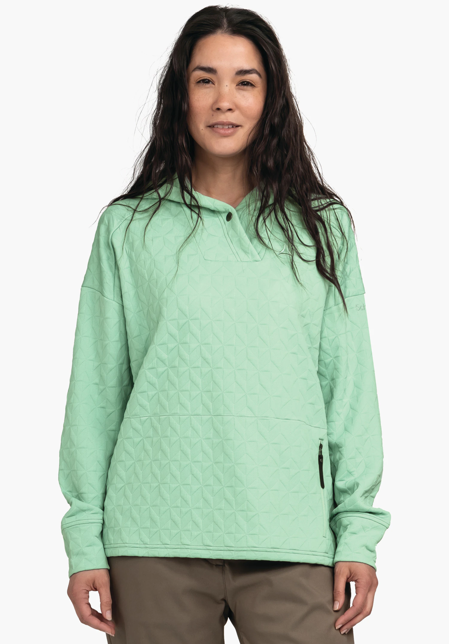 Hoody Style Vindave WMS sweat à capuche vert clair, porté par une femme debout; motif géométrique matelassé, poche latérale zippée et manches longues; fond blanc.