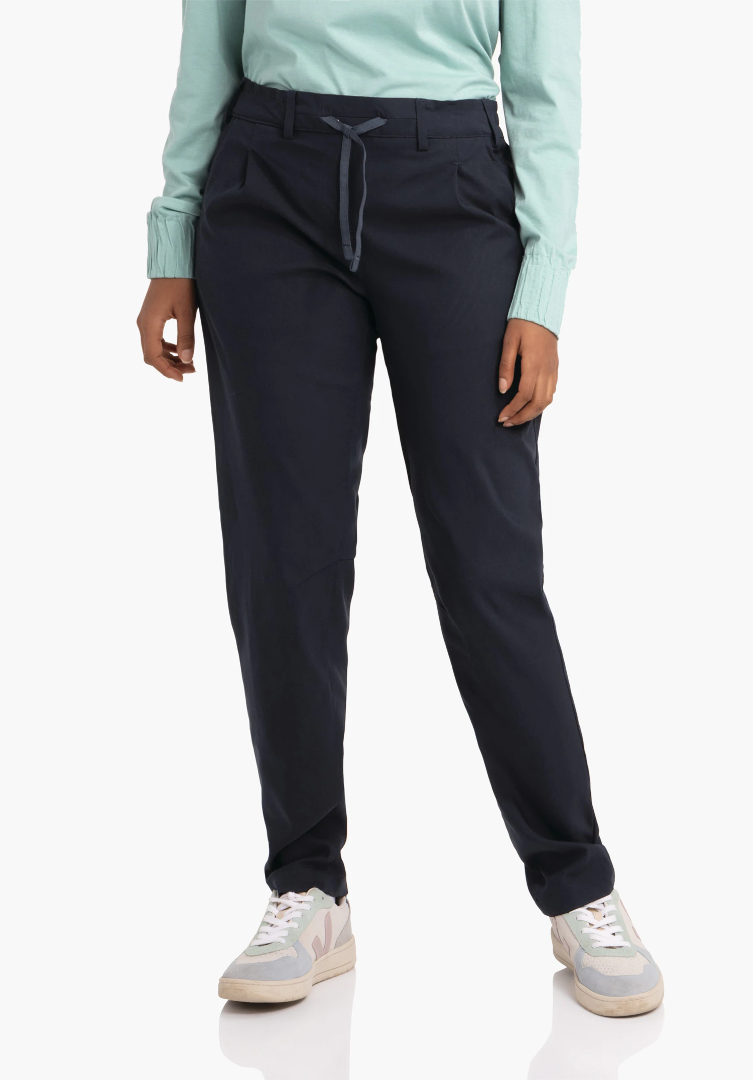 Pants Style Oaktree WMS dark blue casual trousers worn loose by a model; light green top visible, white and pink trainers; model stands against a plain white background.