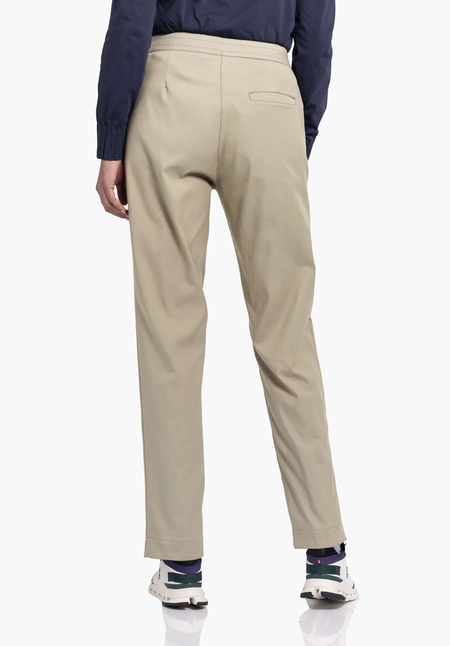 Pants Style Zourga WMS lichtgele broek, van achteren gedragen; persoon staat en draagt een donkerblauwe blouse, witte sneakers met donkergroene accenten en paarse sokken; witte studioachtergrond.