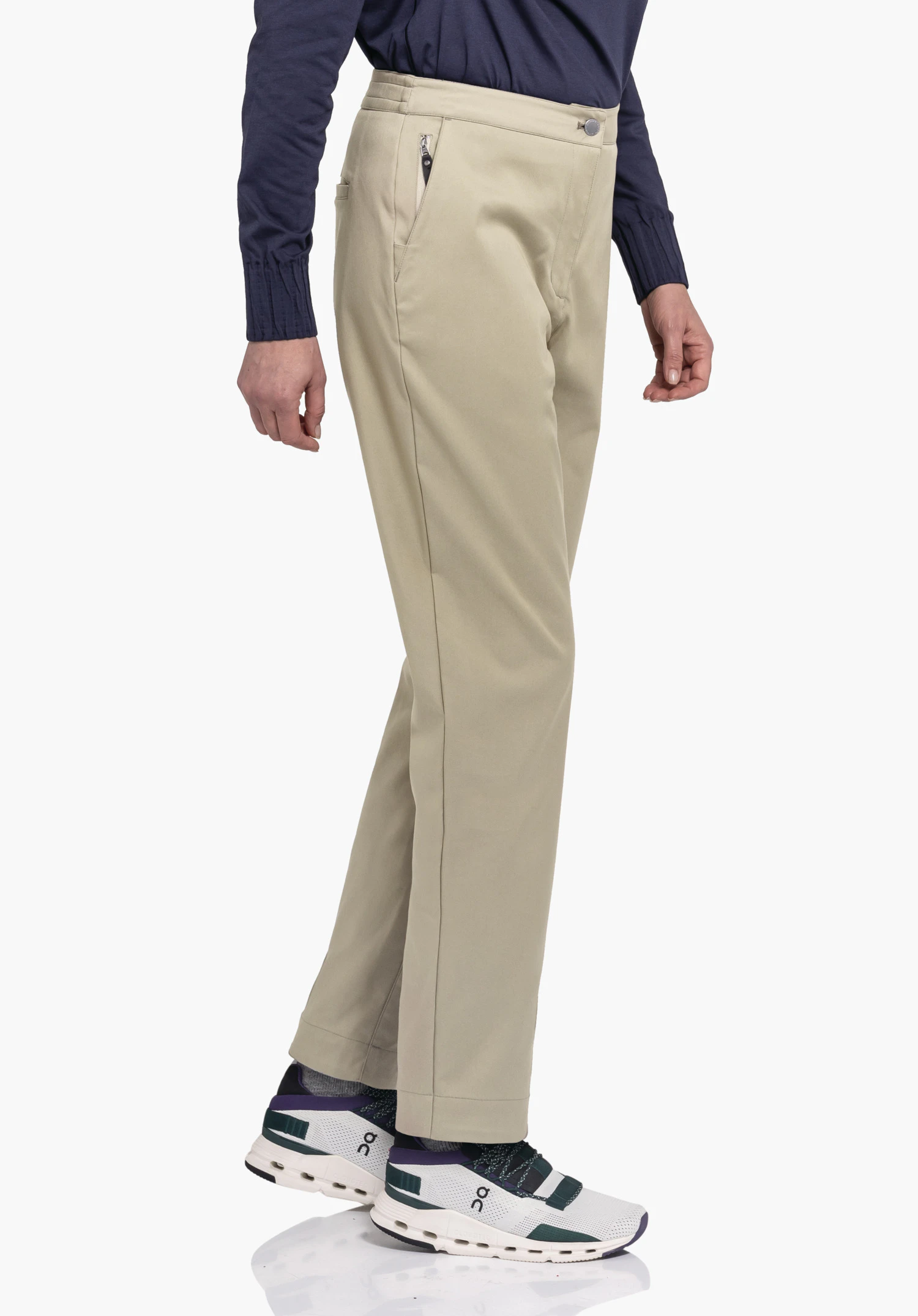 Pants Style Zourga WMS broek, zijwaarts gedragen door een staande persoon met losse pasvorm; persoon draagt een donkerblauw bovenstuk; scenario: studio met effen achtergrond. Tekst: "on".