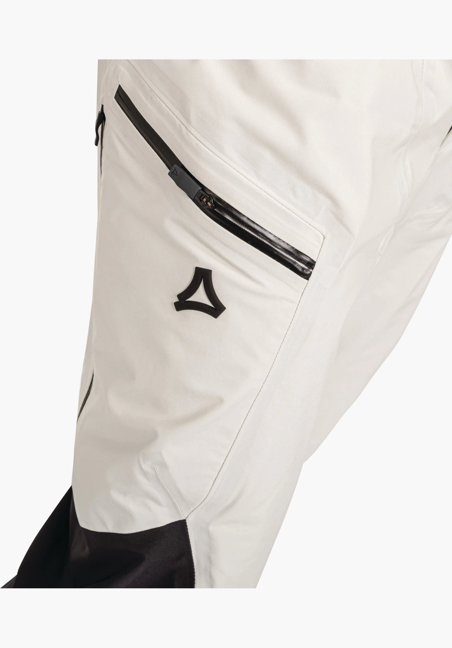 Pants Style Lufeld MNS displaying the contrasting black zip of the thigh pocket and the raised Schöffel logo on the nature-coloured fabric. Close-up against a white/neutral background.