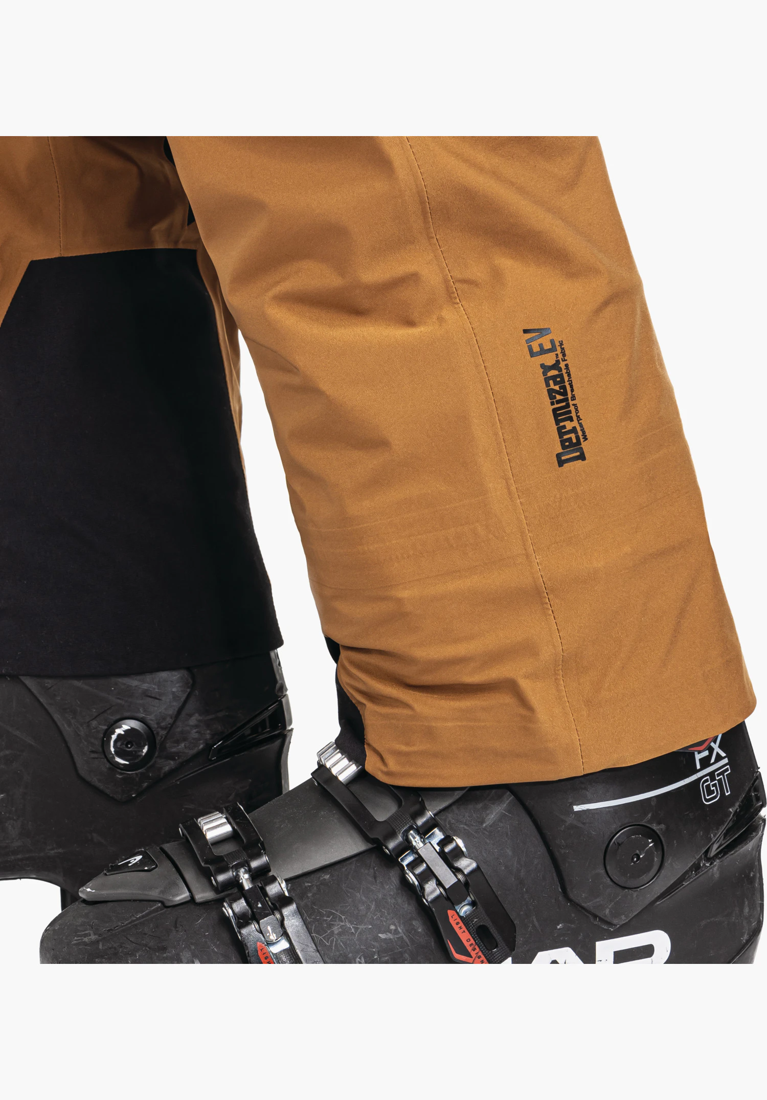 Pants Style Lufeld MNS zeigt den Hosenbeinabschluss in Braun mit schwarzem Dermizax EV Schriftzug und verstärktem Kantenschutz am Innenbein, Nahaufnahme vor weißem Hintergrund.