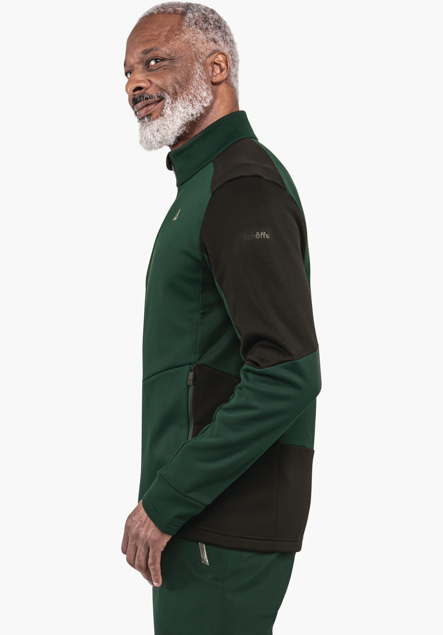 Fleece Jk Style Pontre MNS man wears a dark green and black jacket with Schöffel logo, stands side-on and smiles in front of a white background. Sleeve text: "Schöffel".