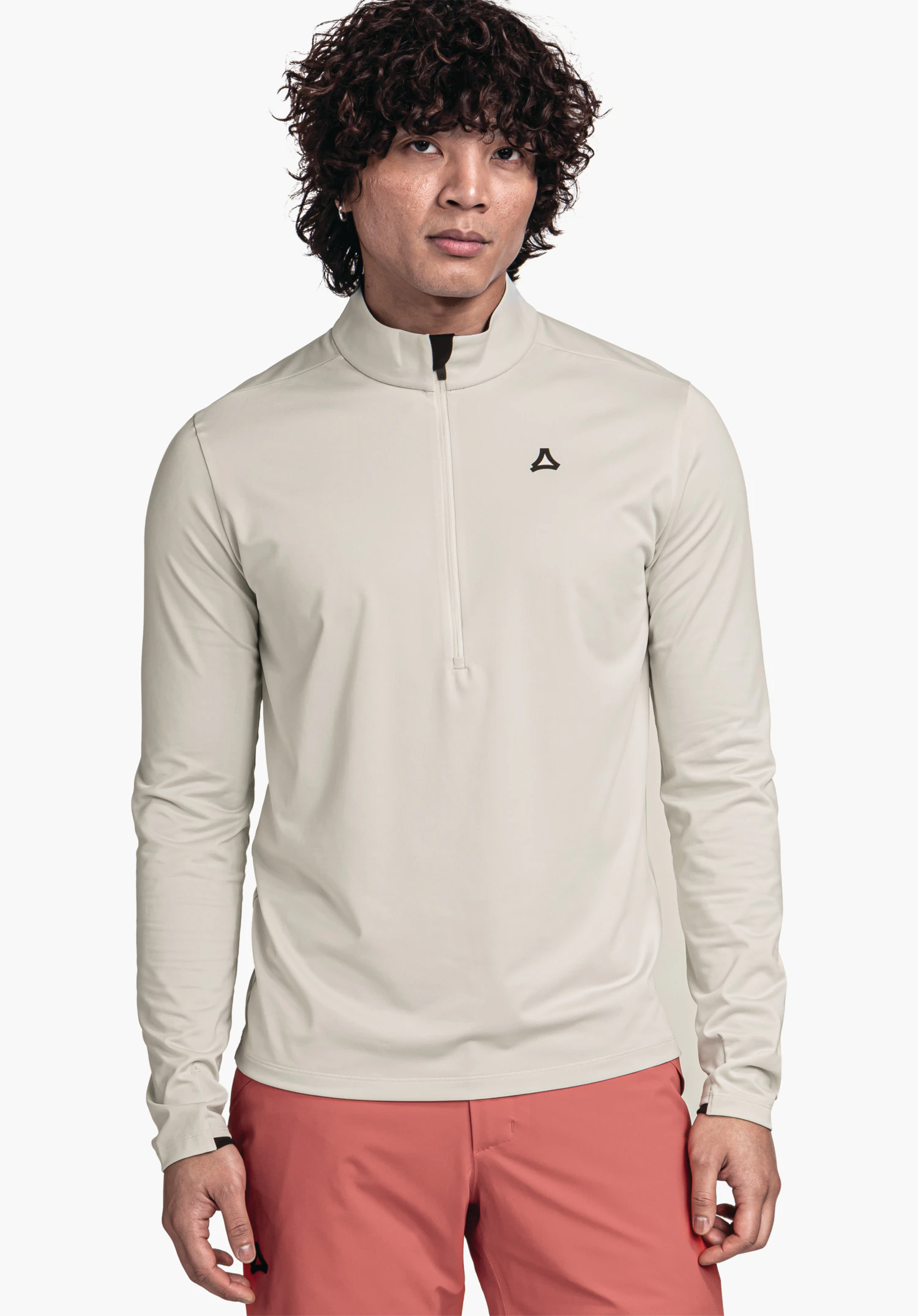 Longsleeve Style Pine MNS homme portant un haut manches longues blanc clair à demi-fermeture éclair avec logo Schöffel sur la poitrine, debout de face devant un fond blanc, associé à un pantalon rouge.