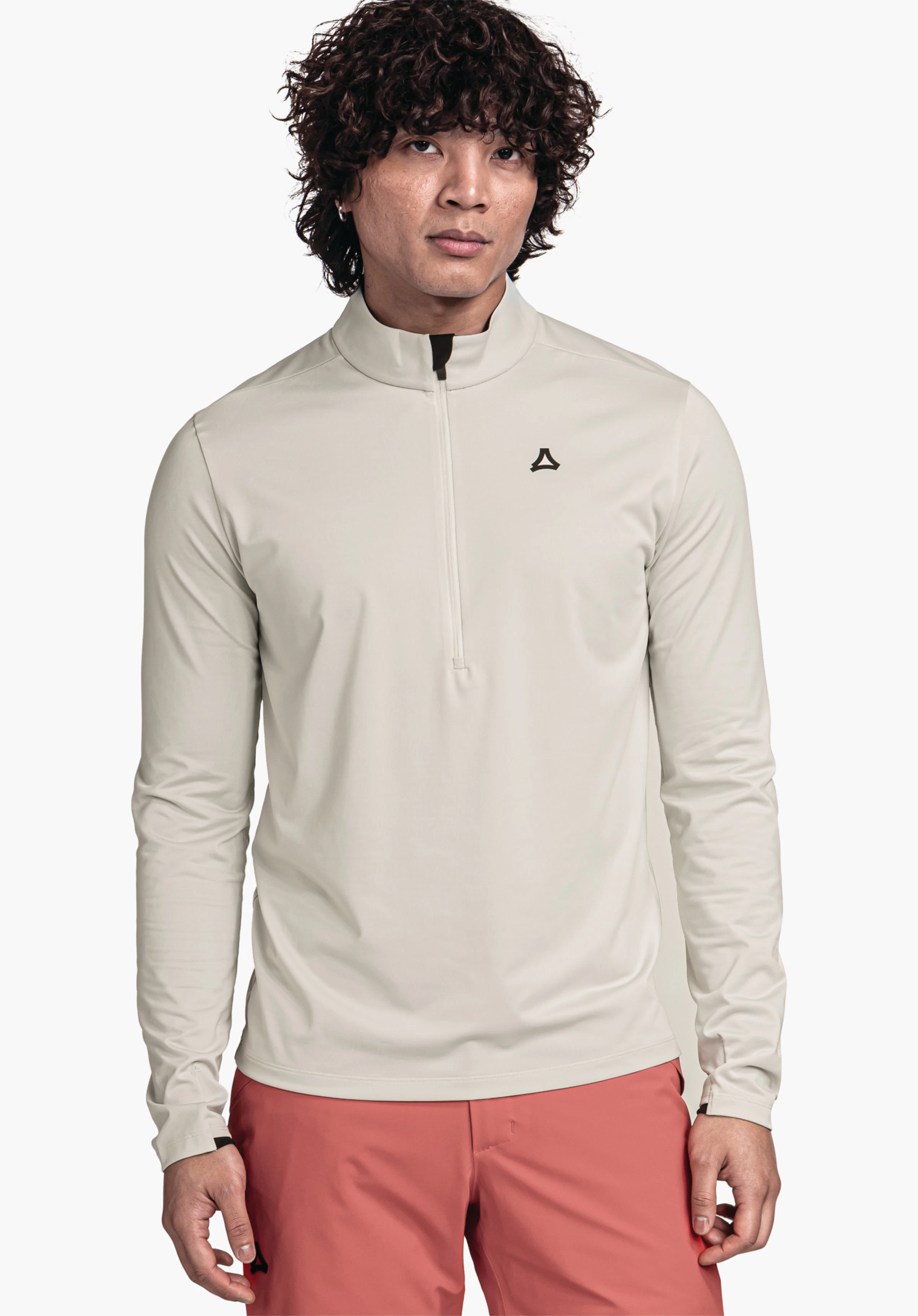 Longsleeve Style Pine MNS homme portant un haut manches longues blanc clair à demi-fermeture éclair avec logo Schöffel sur la poitrine, debout de face devant un fond blanc, associé à un pantalon rouge.