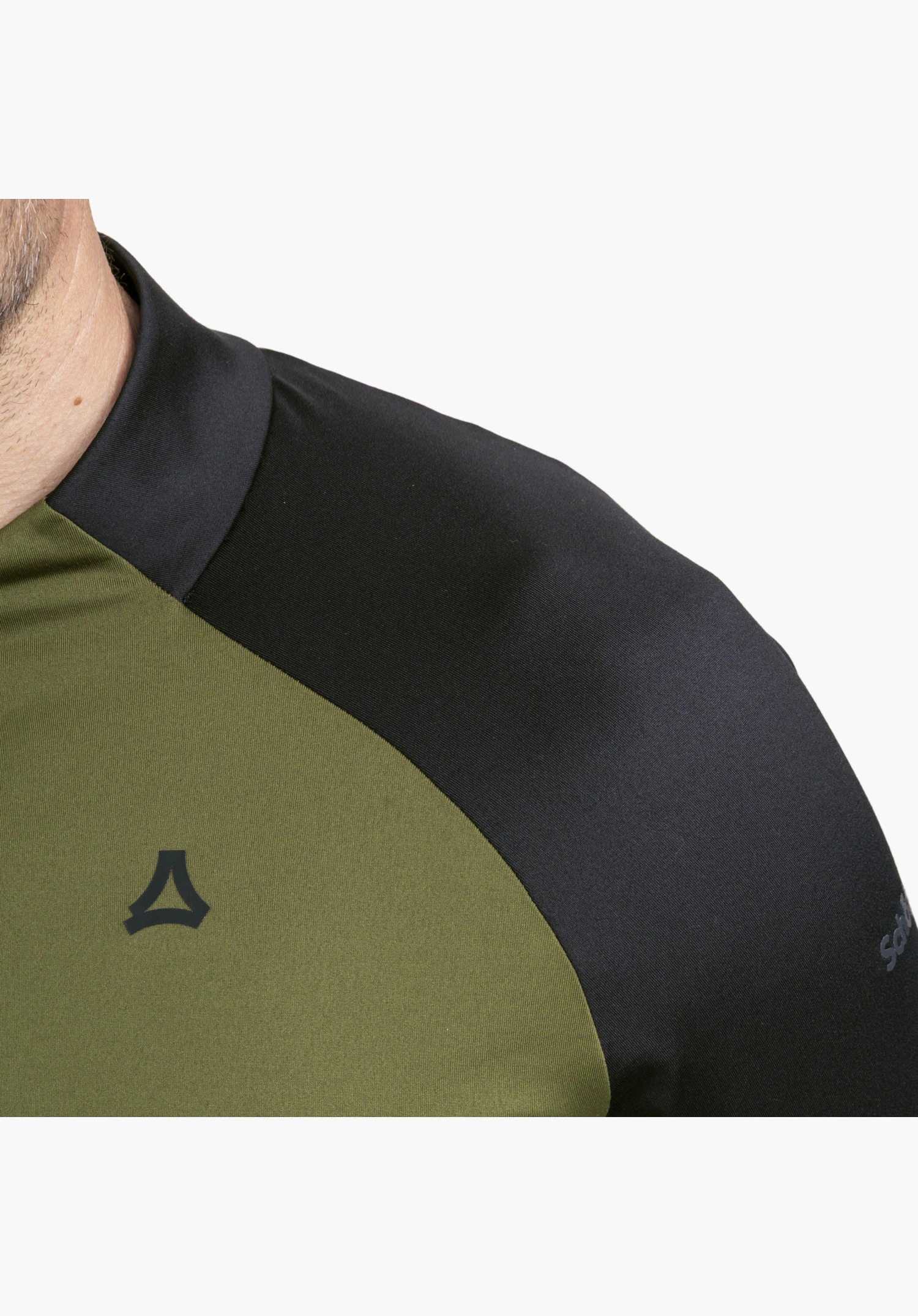 Longsleeve Style Safoon MNS showing the shoulder and collar area in green and black featuring the Schöffel logo in a close-up against a white background.