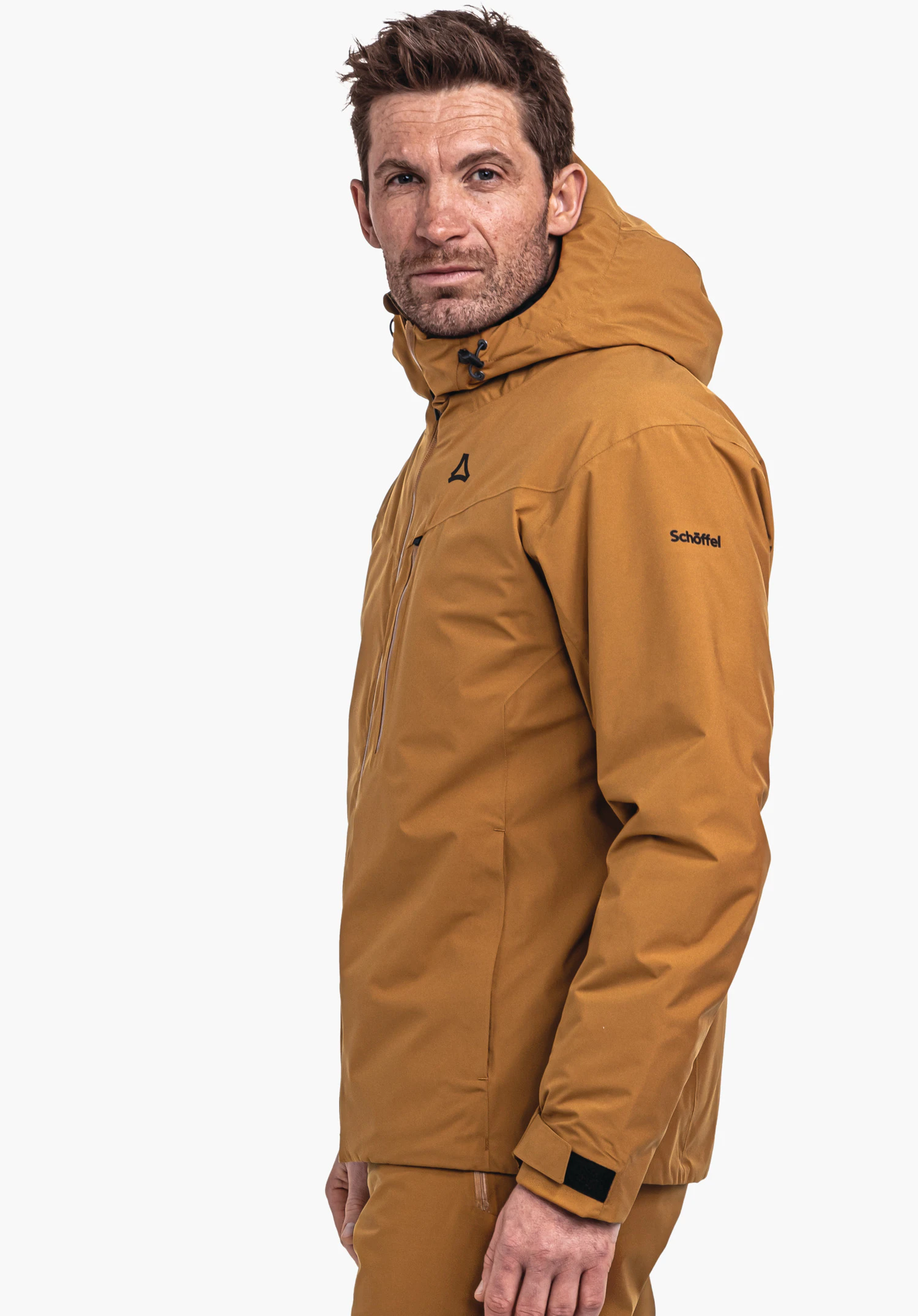 Jacket Style Nollen MNS donkergele jas met capuchon, Schöffel-logo op de borst en tekst "Schöffel" op de mouw; gedragen door een man in zijaanzicht voor een witte achtergrond.