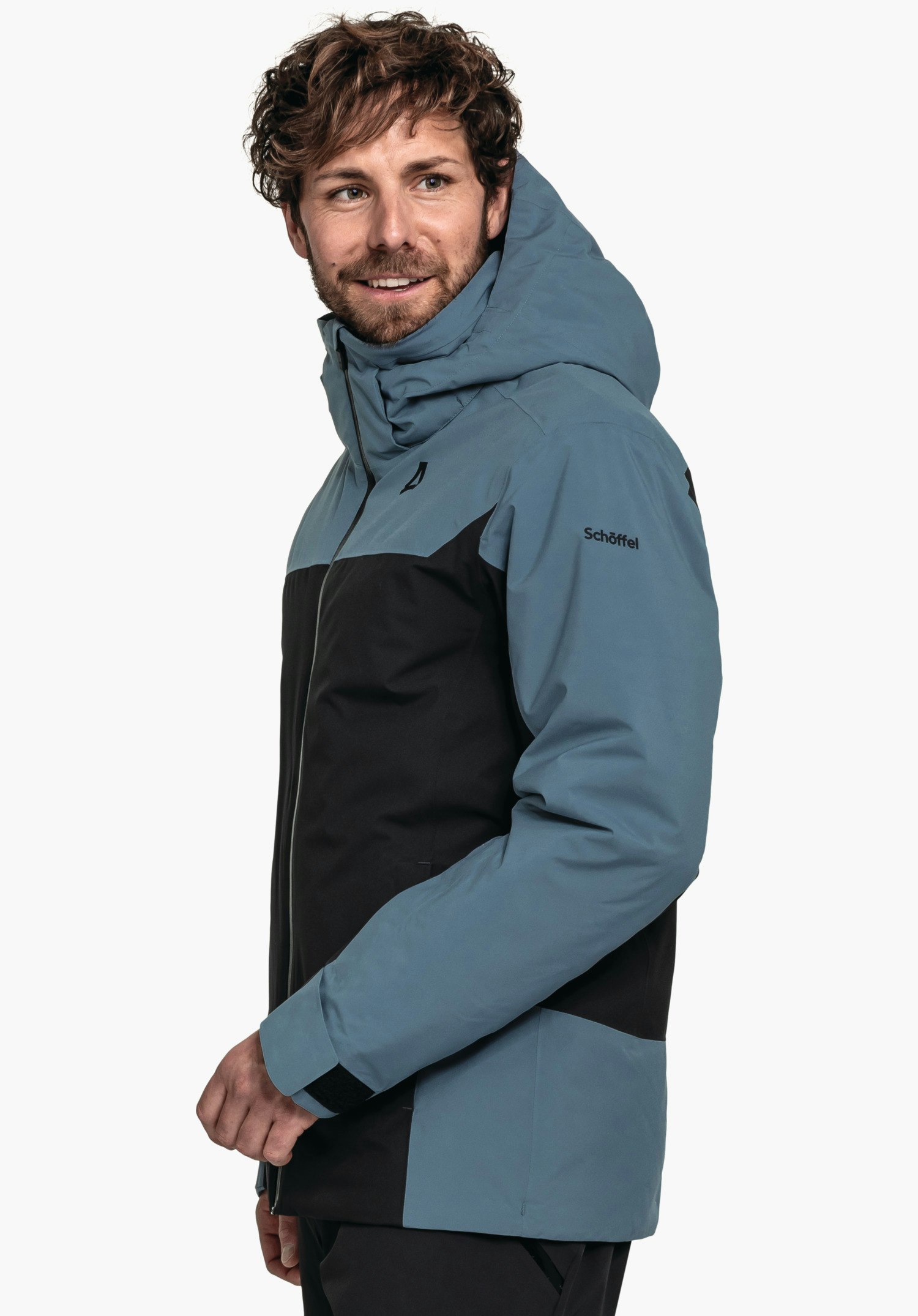 Jacket Style Zandwel MNS Dunkelblau-schwarze Jacke, von Mann seitlich getragen, Blick nach rechts, Schöffel-Logo auf der Brust, Schriftzug "Schöffel" auf dem Ärmel, weißer Studiohintergrund.