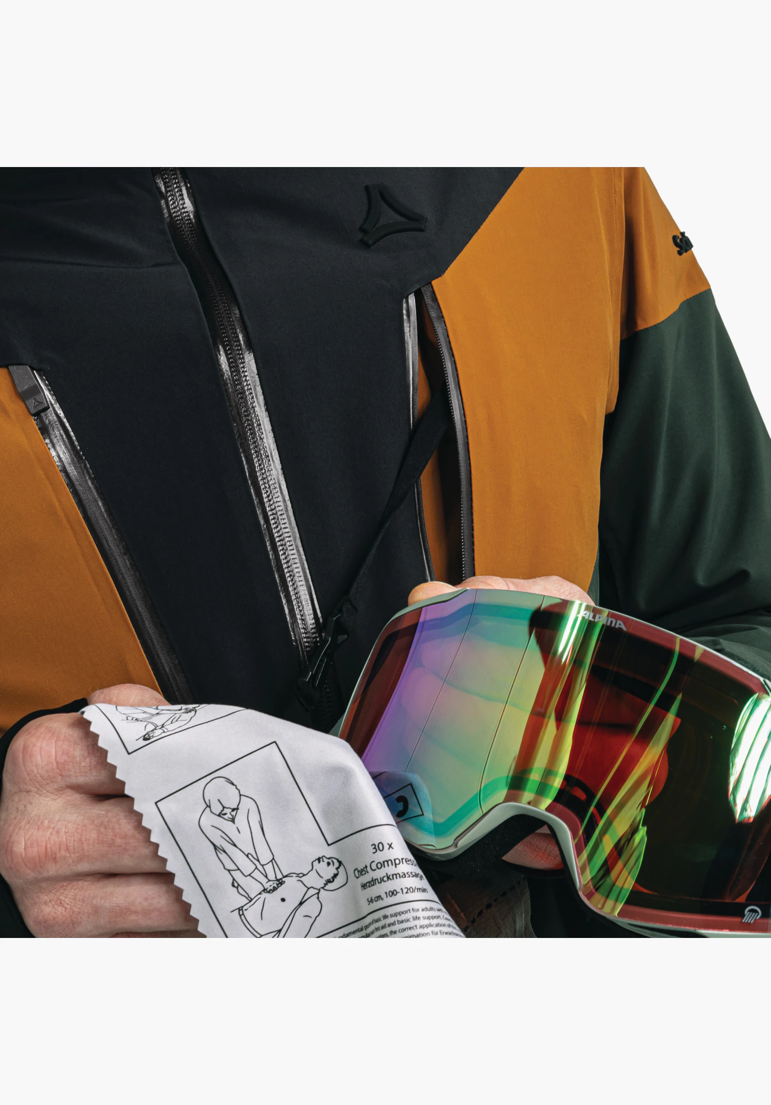 Jacket Style Safuna MNS, détail de la chiffonnette pour lunettes tenue avec imprimé de premiers secours devant la veste verte, avec logo Schöffel visible dans la partie supérieure, gros plan sur fond blanc/neutre.