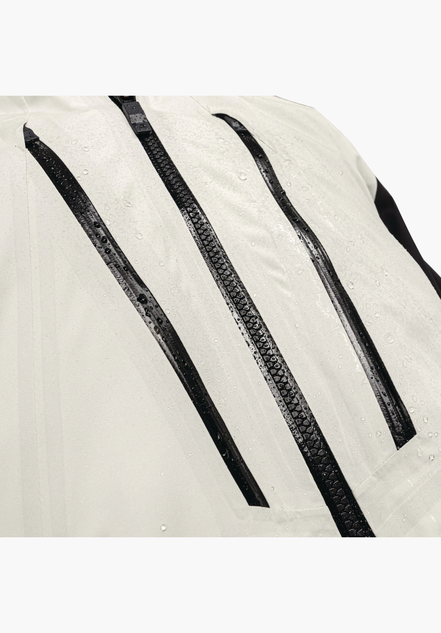 Shell Jk Style Lufeld MNS shows the water-repellent fabric in nature with beading water droplets and the black, waterproof zips on the chest. Close-up against a white background.