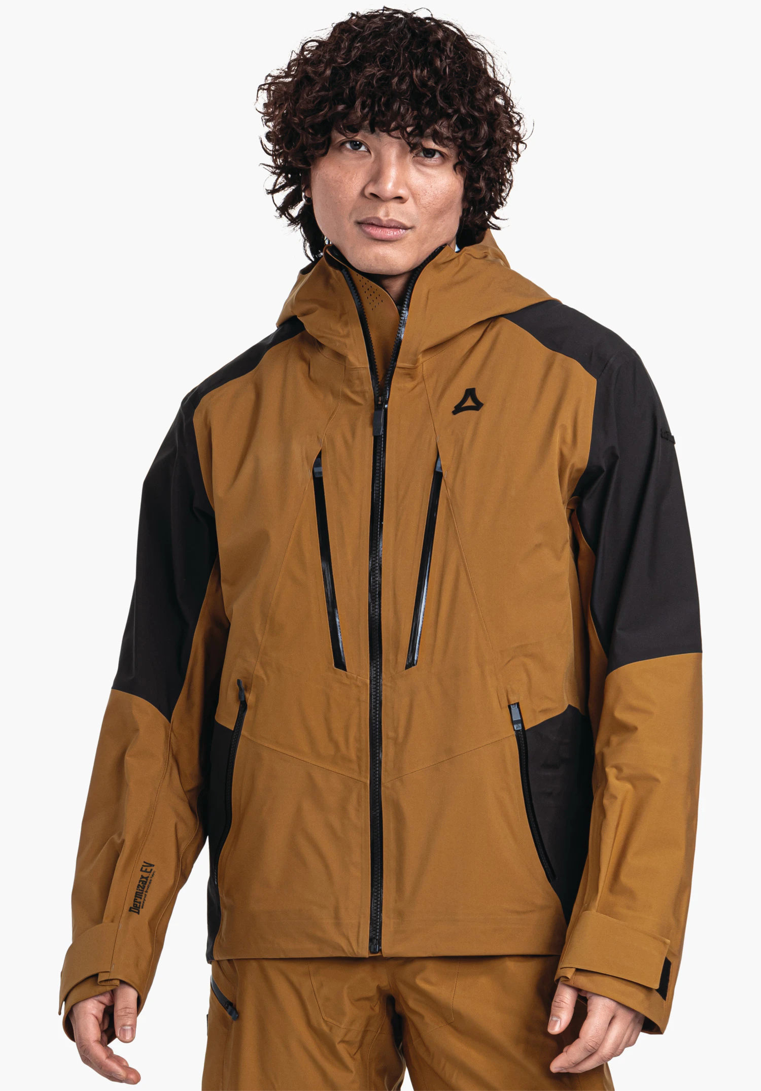 Shell Jk Style Lufeld MNS dunkelgelbe Jacke mit schwarzen Einsätzen, von einem Mann frontal getragen, Reißverschlüsse sichtbar, Kapuze hoch, vor weißem Hintergrund im Studio, mit Schöffel-Logo auf der Brust. Text: "Dermizax EV" (linker Unterarm).