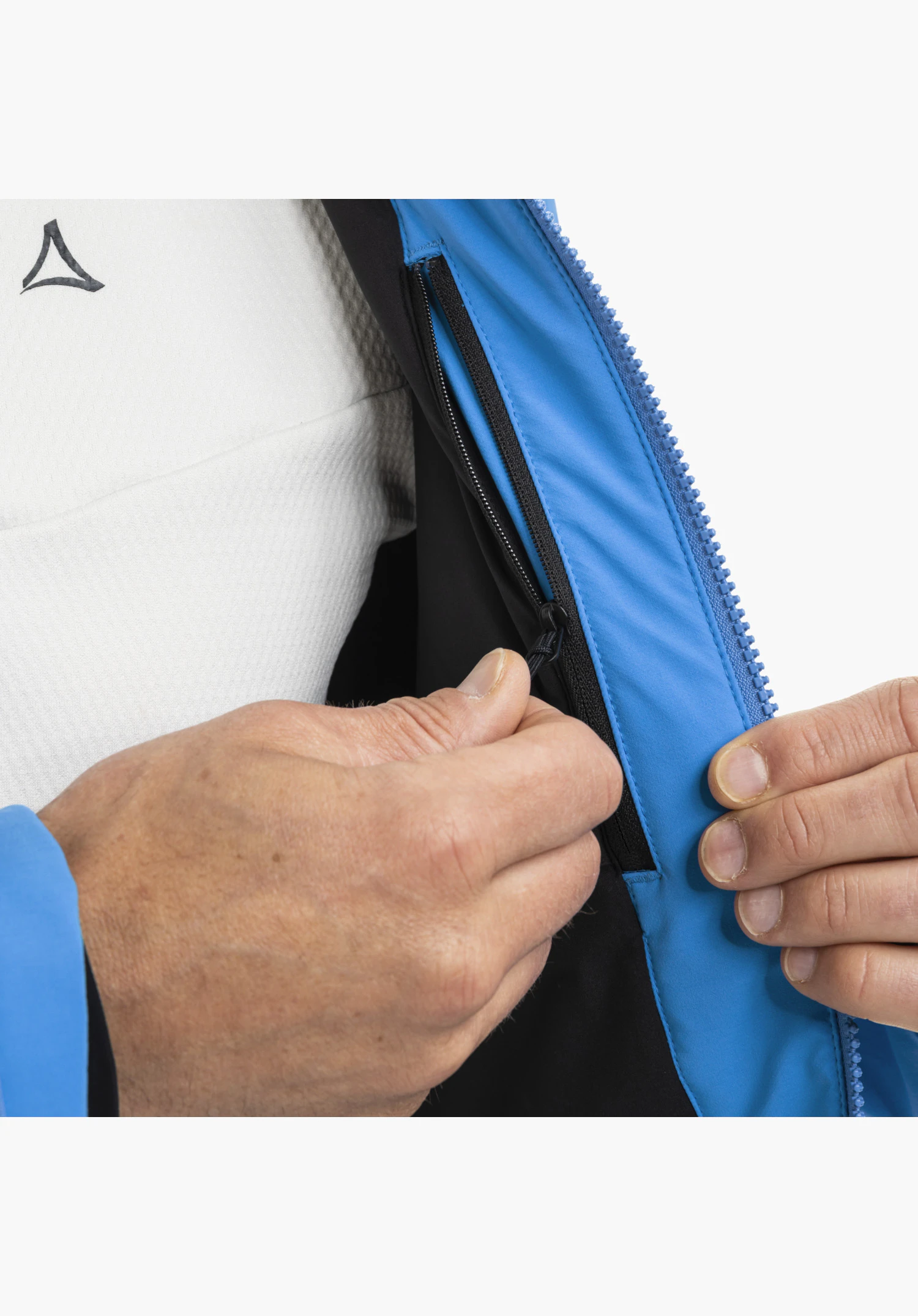Jacket Style Skuta MNS in blue shows a close-up of the inner pocket with zipper and black lining, operated by a hand close-up against a white/neutral background.