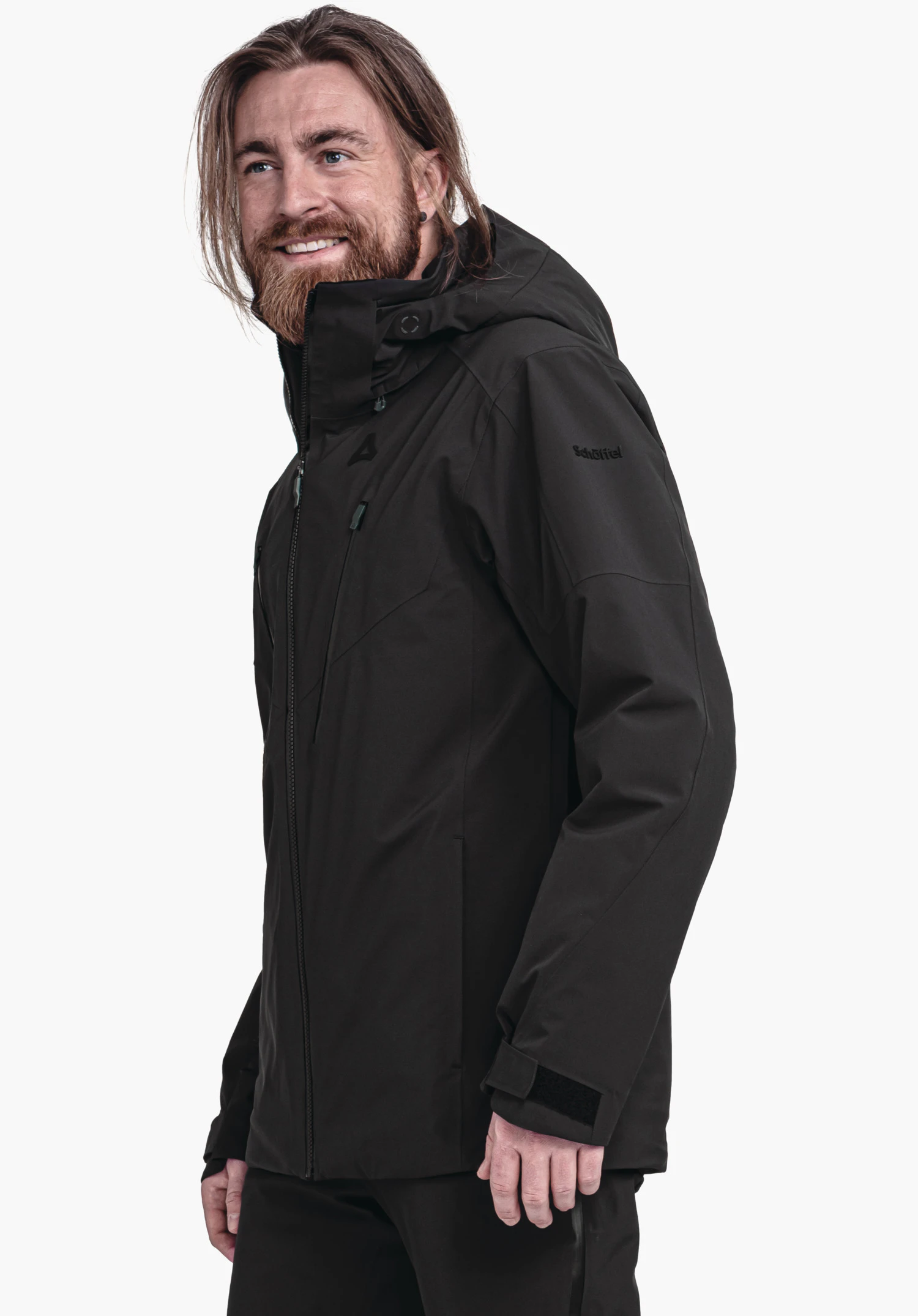 Jacket Style Skuta MNS schwarze Outdoor-Jacke: Mann trägt sie lächelnd im Halbprofil vor weißem Hintergrund; Schöffel-Logo auf Brust, Schriftzug auf Ärmel: "Schöffel".