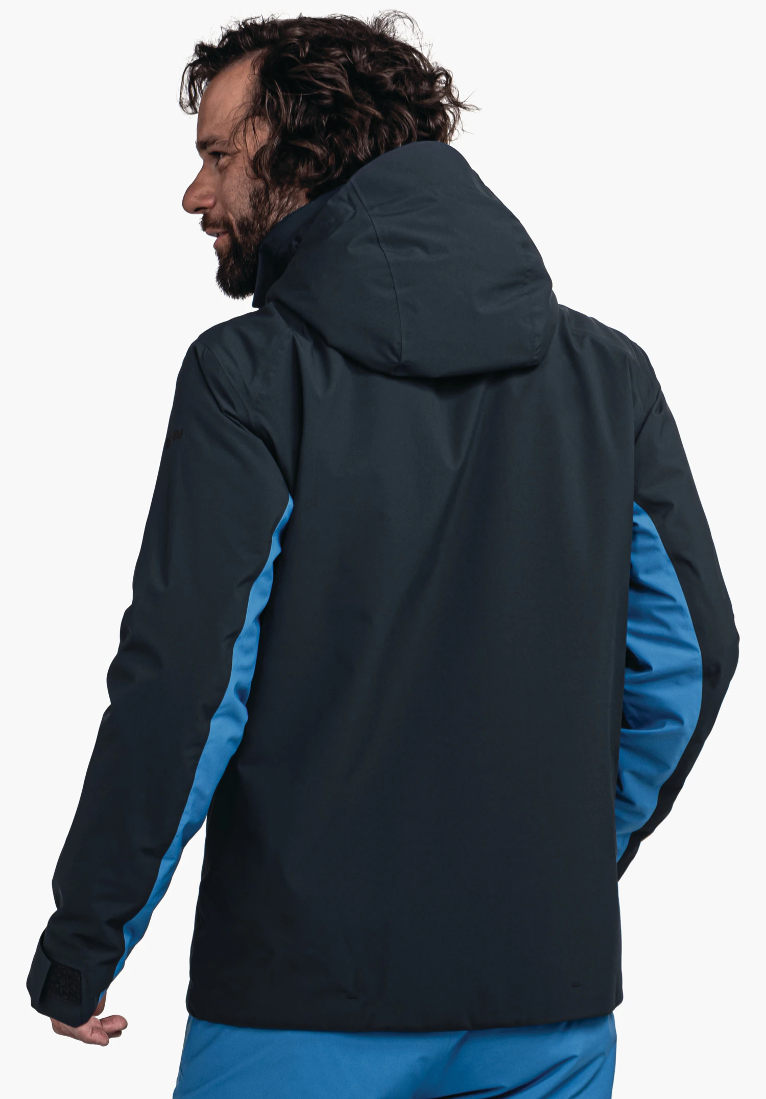 Jacket Style Trifex MNS dark blue jacket with light blue trim; worn by a man looking over his left shoulder; hood up; standing against a white background.