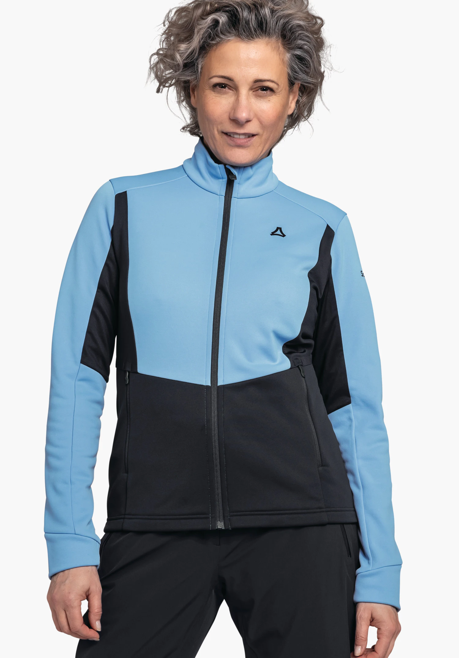 Fleece Jk Style Pontre WMS Hellblaue und schwarze Sportjacke, von einer stehenden Person frontal getragen; Reißverschluss geschlossen; Schöffel-Logo auf der Brust; neutraler weißer Hintergrund.