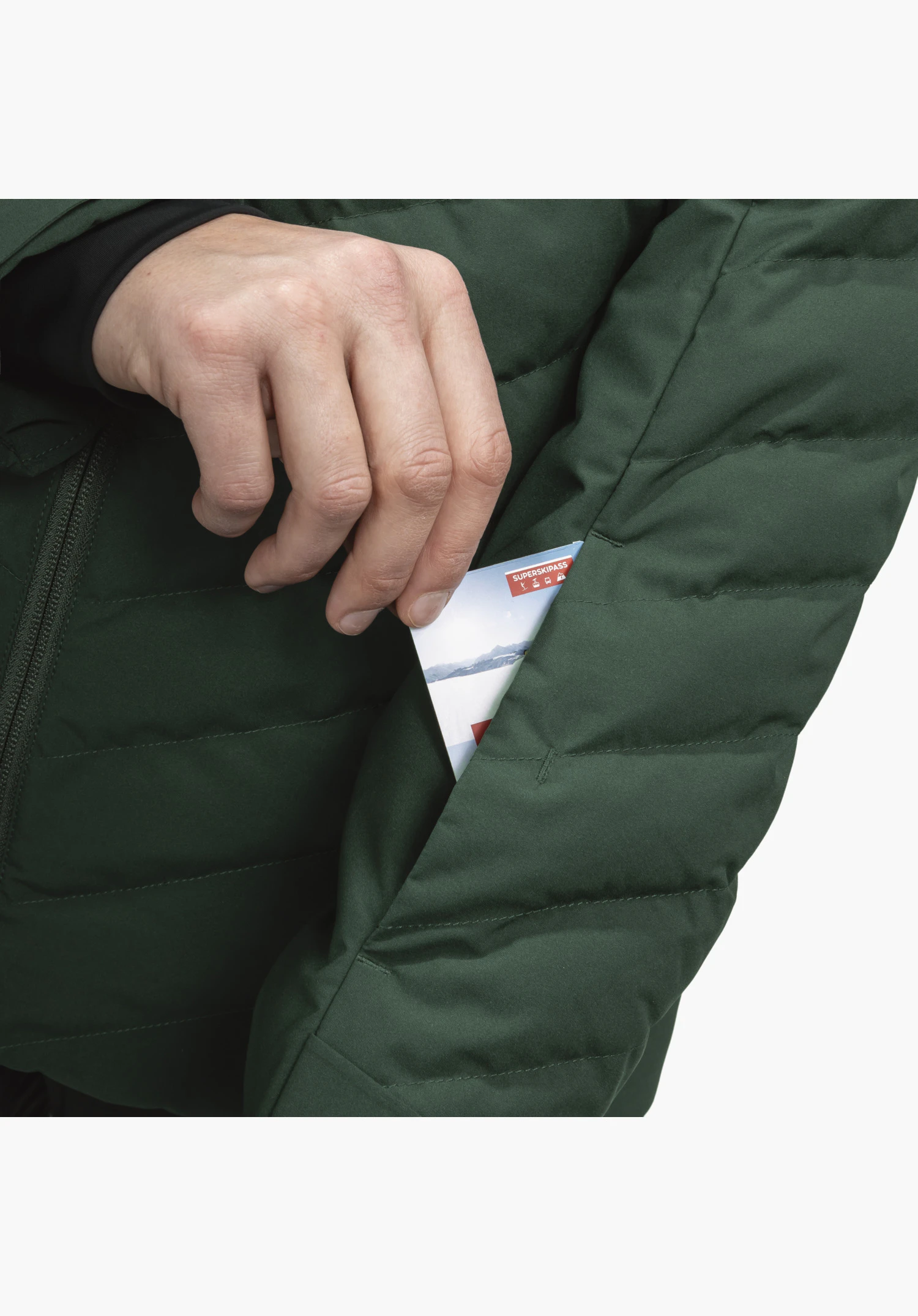 Jacket Style Alerce WMS toont de praktische skipaszak op de mouw van de groene gewatteerde jas, waarin een hand een skipas steekt. Close-up voor een witte/neutrale achtergrond.
