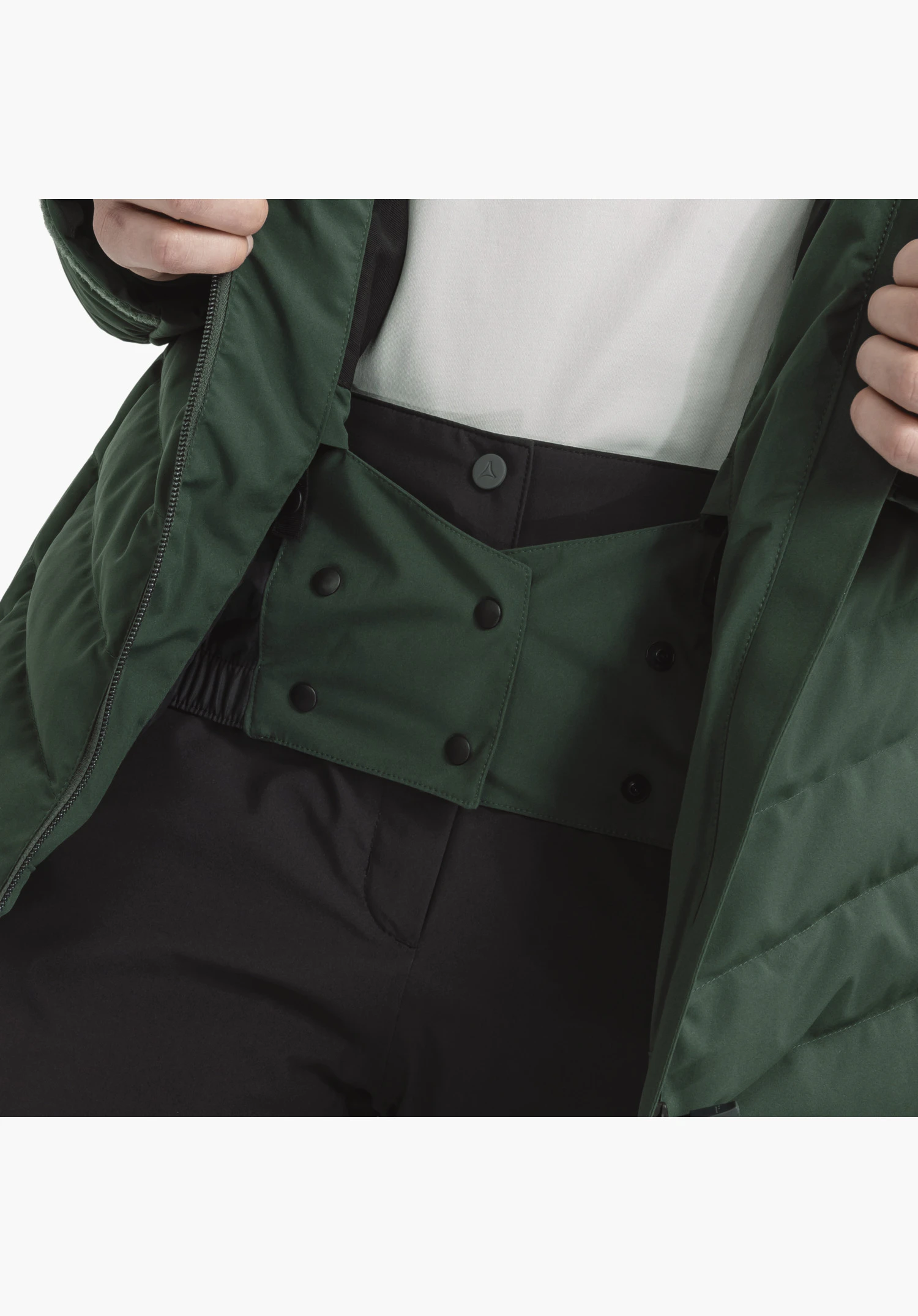 Jacket Style Alerce WMS toont de interne groene sneeuwvanger met zwarte drukknopen en Schöffel-logo detail als close-up voor een witte achtergrond.