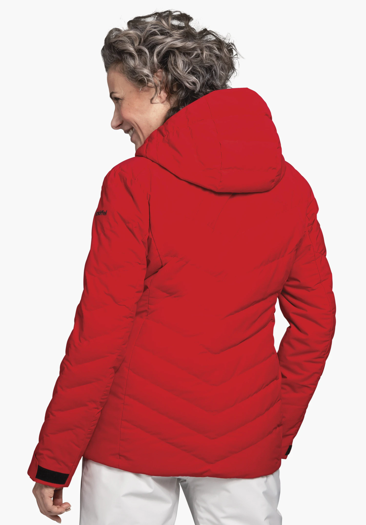 Jacket Style Alerce WMS rode jas met capuchon, achteraanzicht; gedragen door een staande vrouw met lichtgrijs haar, zij kijkt naar links voor een witte achtergrond. Tekst op de mouw: "schöffel".