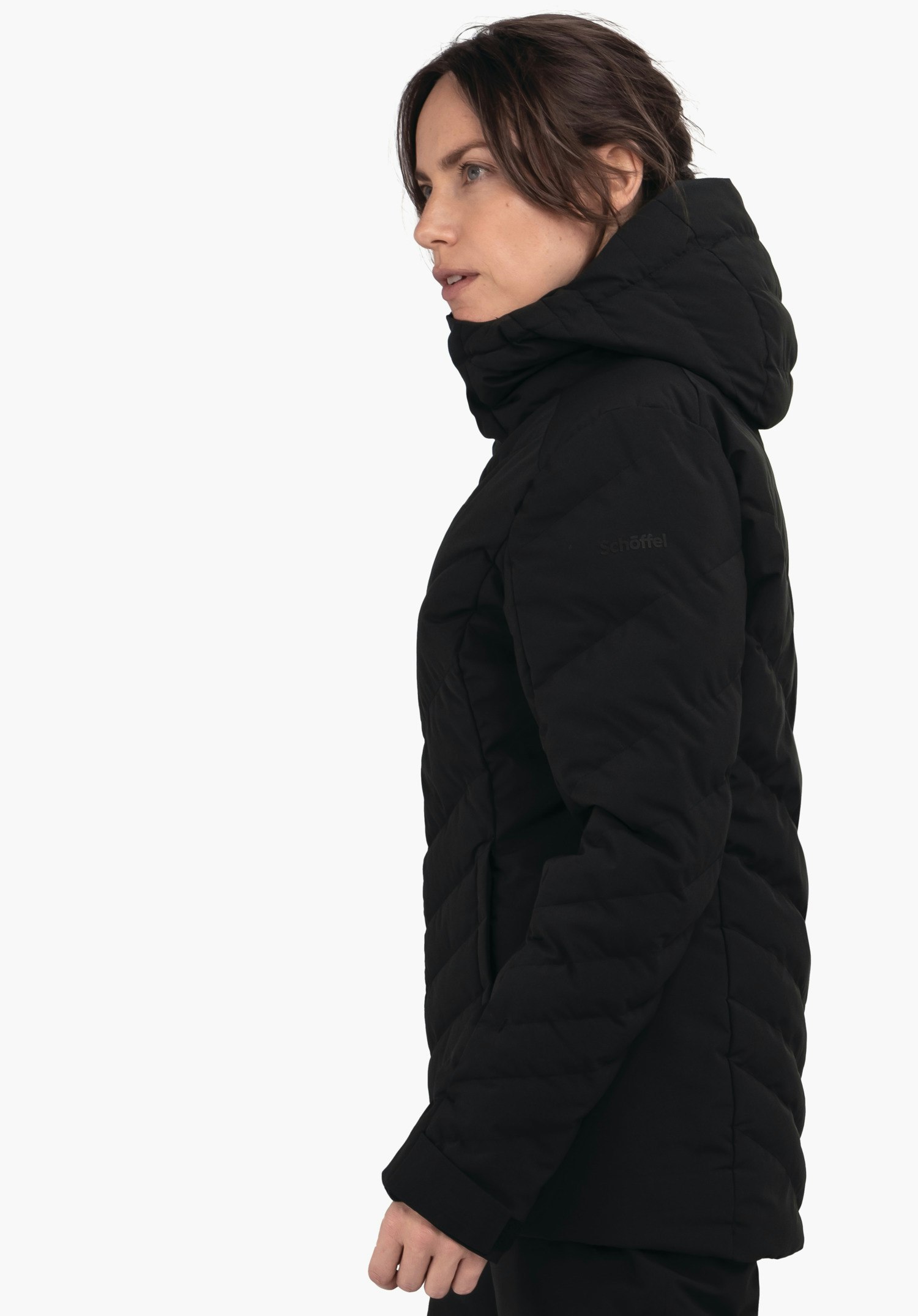 Jacket Style Alerce WMS black quilted hooded jacket, worn sideways by a woman looking to the left against a white background. Text on the jacket: "schöffel".