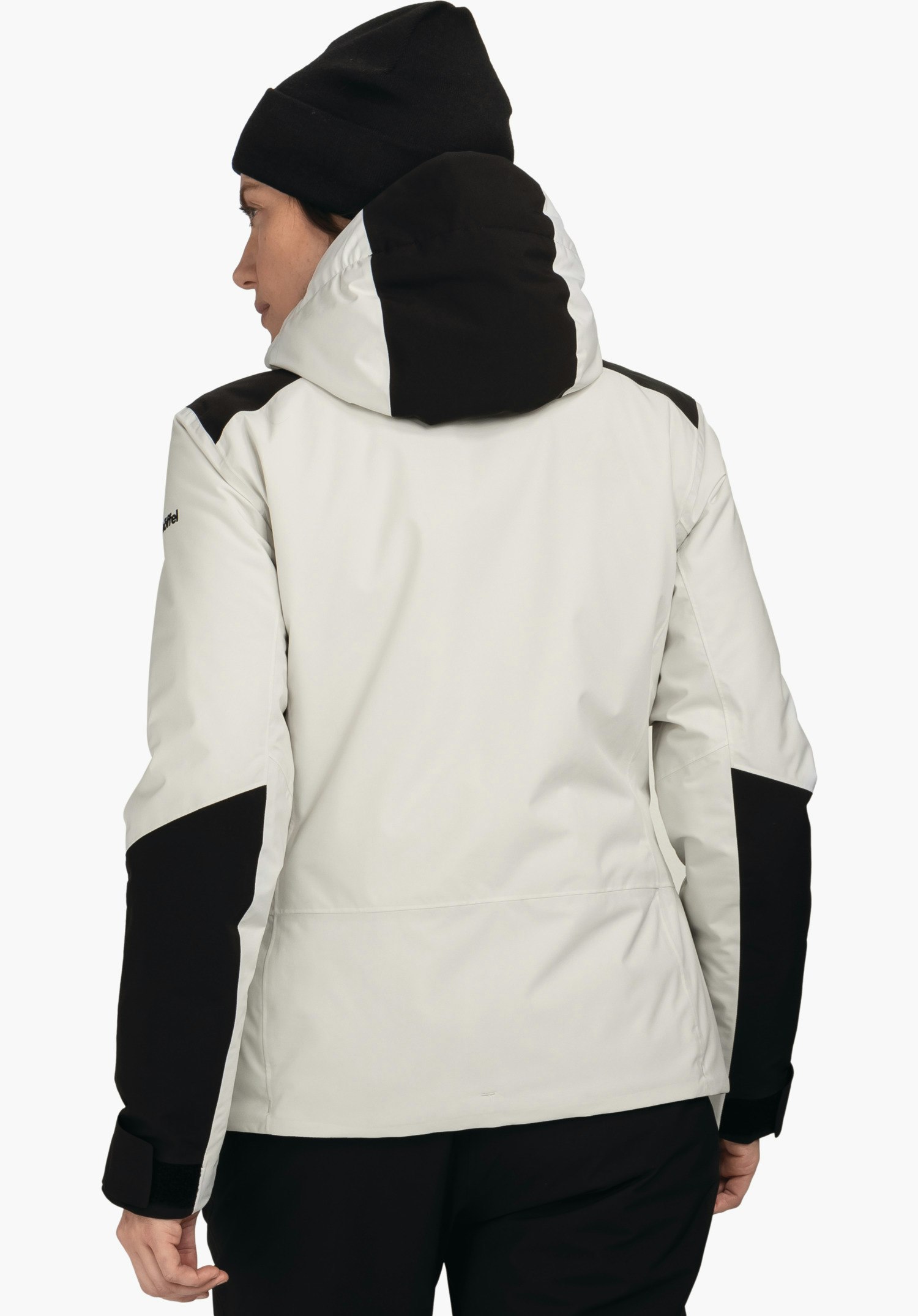Jacket Style Zandwel WMS veste blanc clair avec empiècements noirs, portée par une personne avec bonnet noir, vue arrière, capuche relevée; fond clair. Texte: "Schöffel".