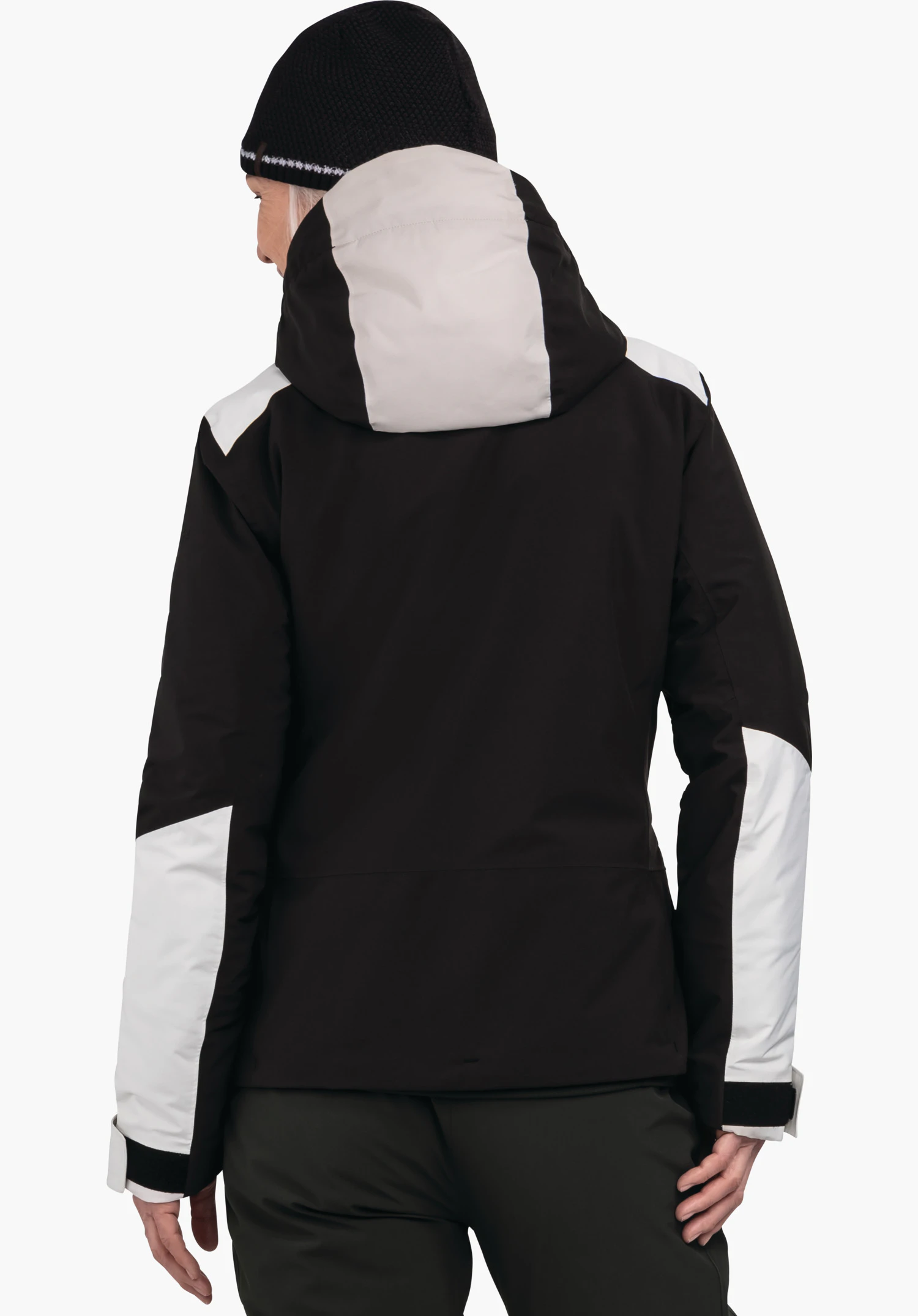 Jacket Style Zandwel WMS veste: personne portant une veste noire avec empiècements blancs et capuche, vue arrière; bonnet noir, pantalon vert foncé, fond blanc.