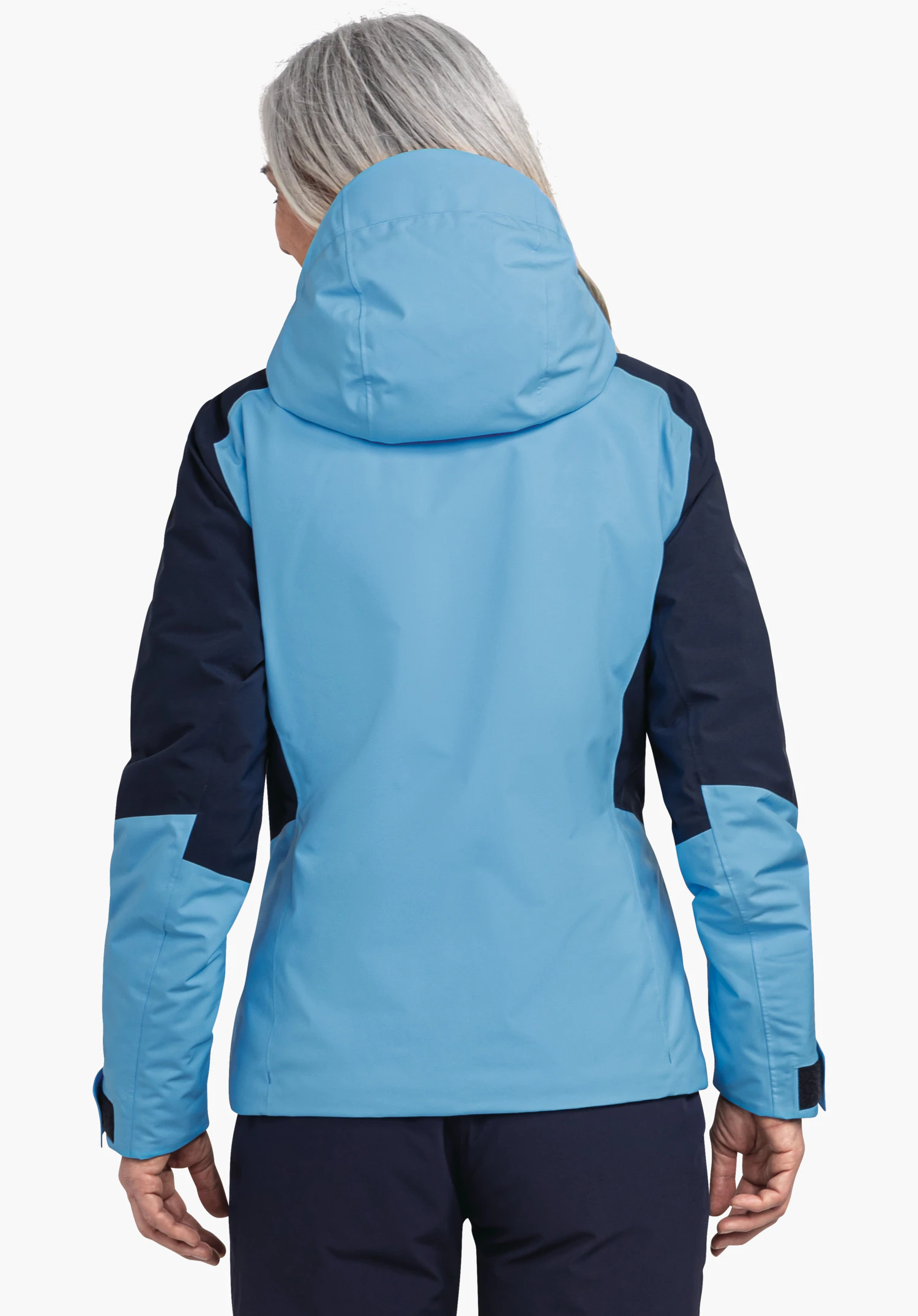 Jacket Style Trifex WMS veste outdoor bleu clair et bleu foncé, portée par une personne, vue arrière; capuche relevée, personne aux cheveux gris clair debout devant un fond clair.