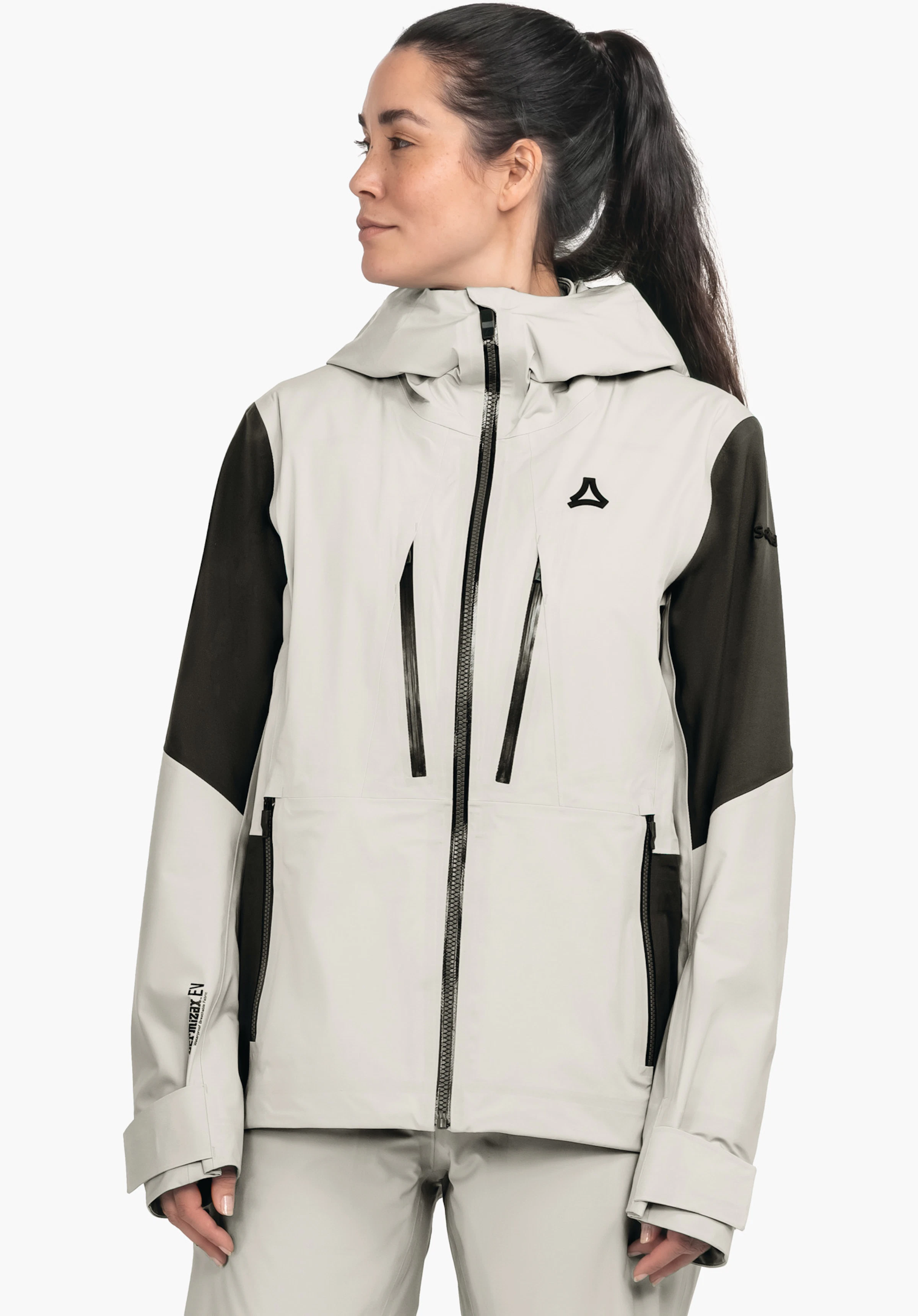 Shell Jk Style Lufeld WMS white jacket with dark green sleeves and Schöffel logo on the chest; worn by a woman with ponytail looking sideways; white studio background; no readable text.
