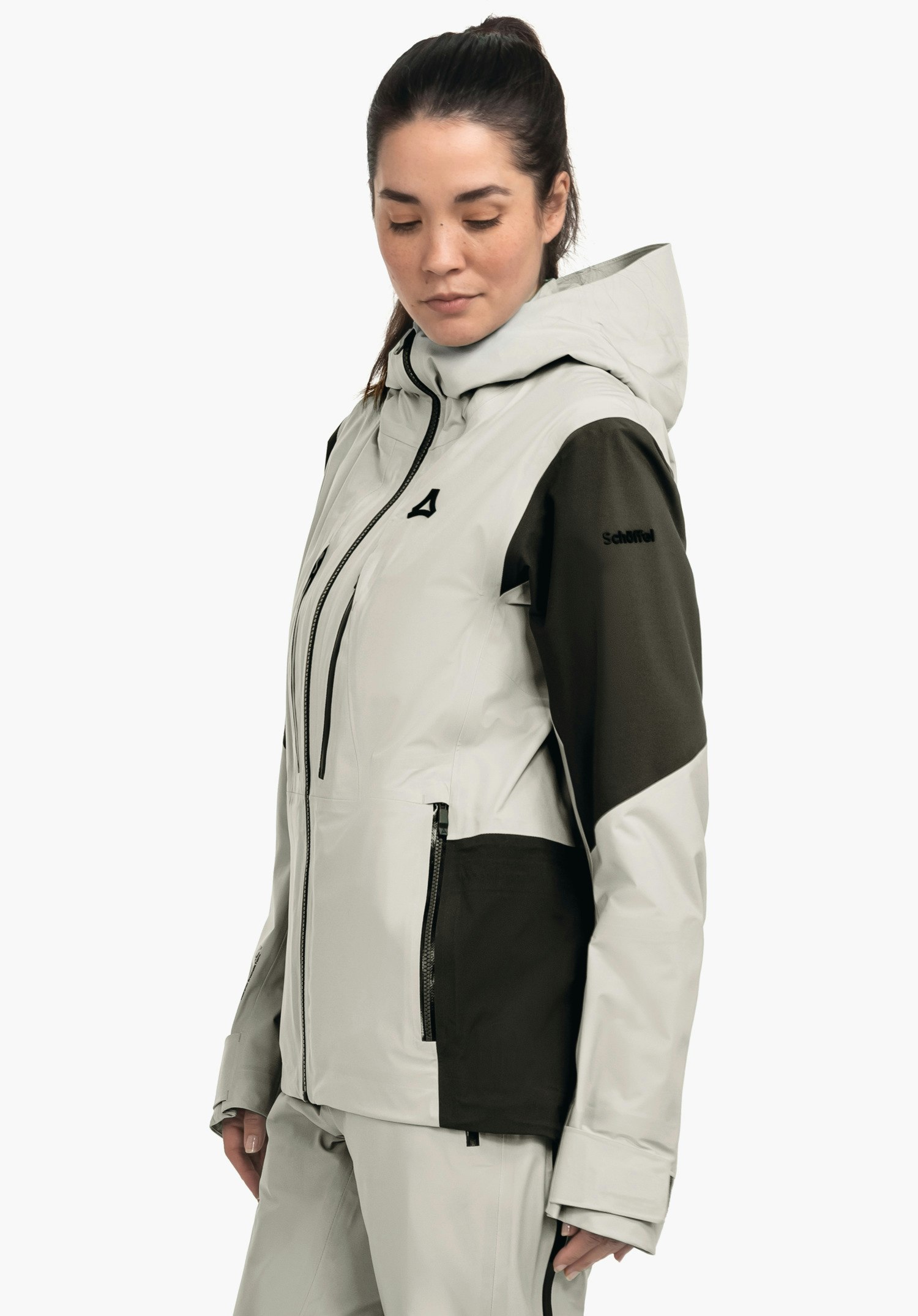 Jacket Style Pontre WMS veste rouge clair, portée par une femme légèrement penchée vers l’avant en souriant; col intérieur noir fin, pantalon noir, fond blanc. Texte sur la manche: "Schöffel". Logo Schöffel sur la poitrine.