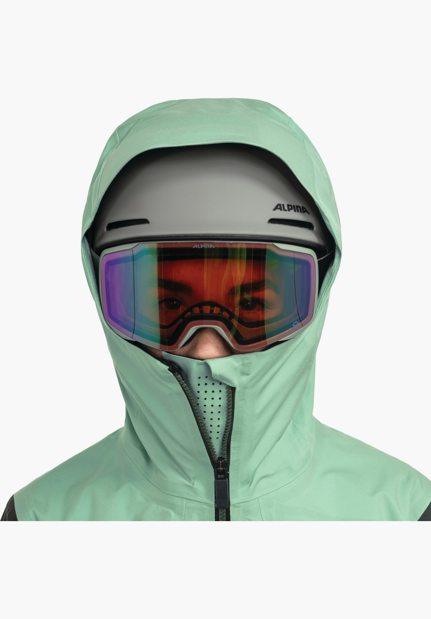 Shell Jk Style Lufeld WMS zeigt den hohen, grünen Kragen mit integrierten Lasercut-Belüftungslöchern im Mundbereich sowie die Passform der helmtauglichen Kapuze über Skihelm und Brille. Nahaufnahme vor weißem Hintergrund.
