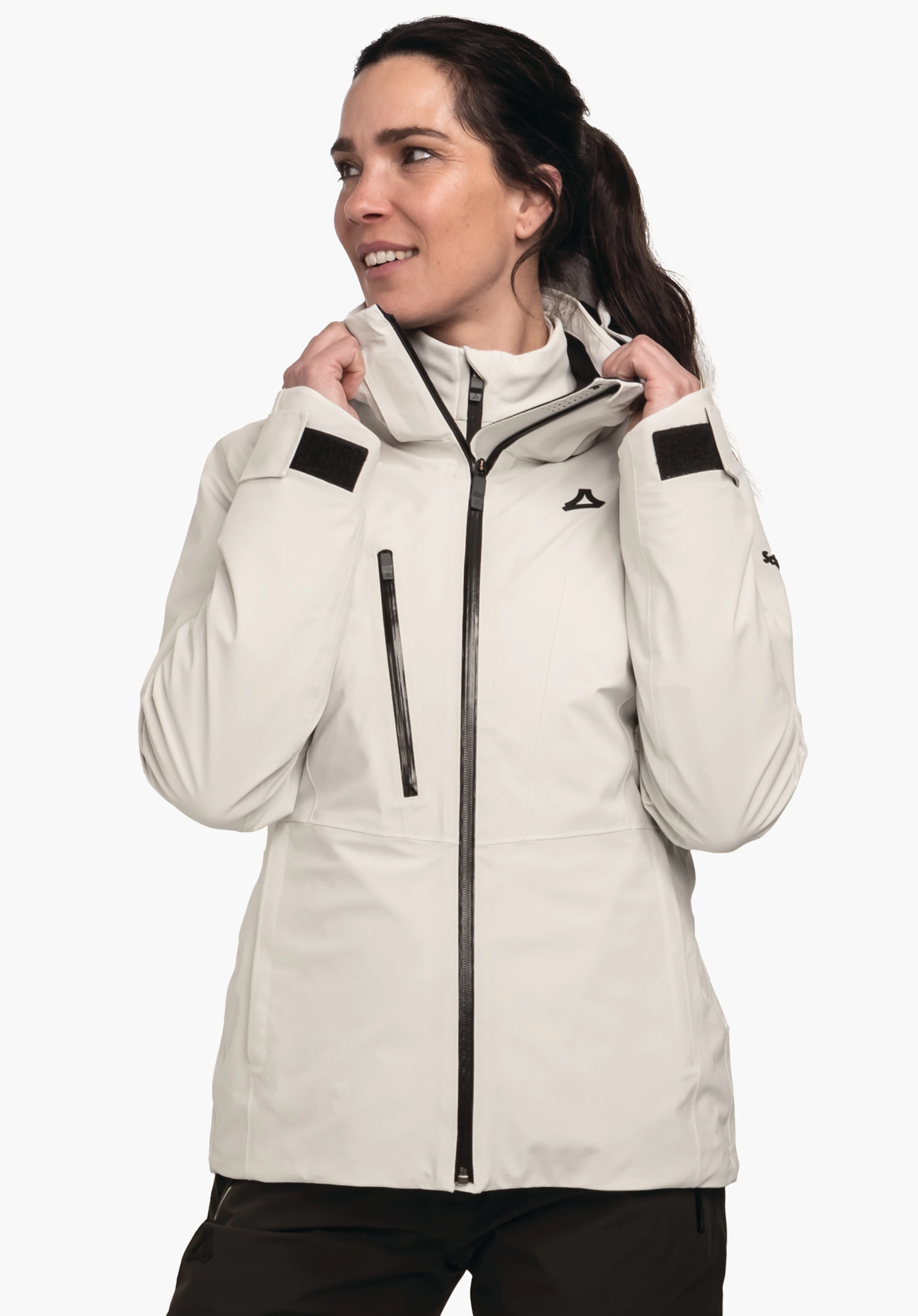 Jacket Style Pontre WMS veste outdoor plus longue blanc clair avec fermeture éclair noire, poche poitrine zippée noire et logo Schöffel; personne tirant le col vers le haut, debout devant un fond blanc.