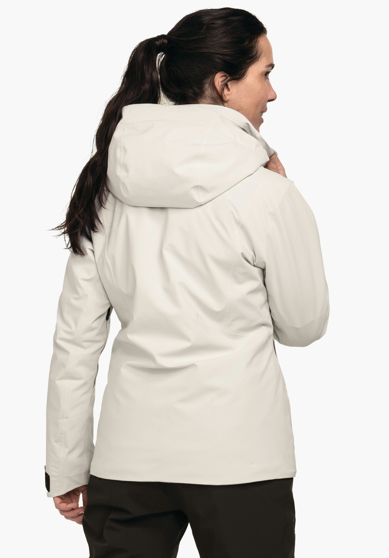 Jacket Style Pontre WMS veste blanc clair; personne se tournant sur le côté et tenant le col, capuche reposant sur le dos; cheveux brun foncé, pantalon brun foncé, fond blanc.