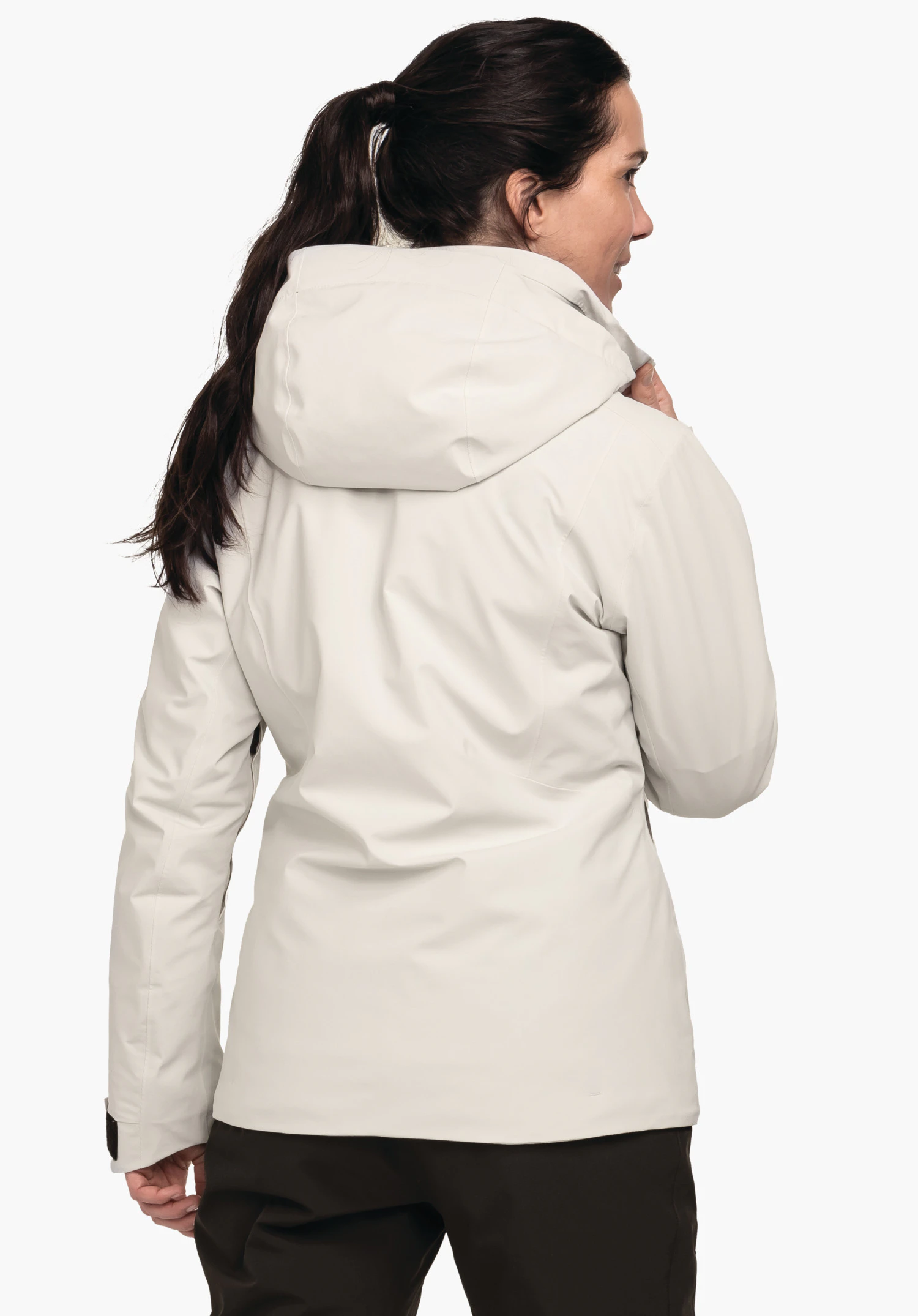 Jacket Style Pontre WMS veste blanc clair; personne se tournant sur le côté et tenant le col, capuche reposant sur le dos; cheveux brun foncé, pantalon brun foncé, fond blanc.