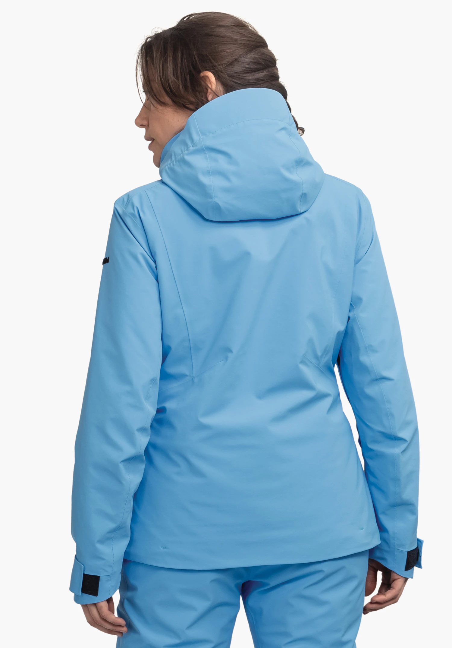 Jacket Style Pontre WMS veste bleu clair couvrant le dos d’une personne, capuche relevée; personne debout avec tête légèrement tournée devant un fond blanc neutre.