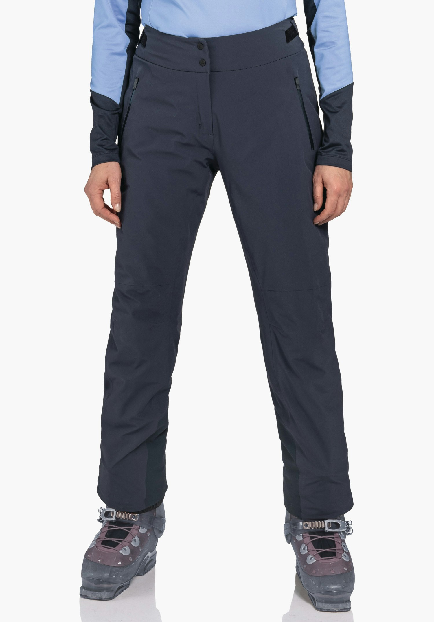 Pants Style Skayra WMS dark blue outdoor trousers shown front-facing on a standing person with slightly apart legs; light blue top, dark red hiking boots with dark grey details; white background.