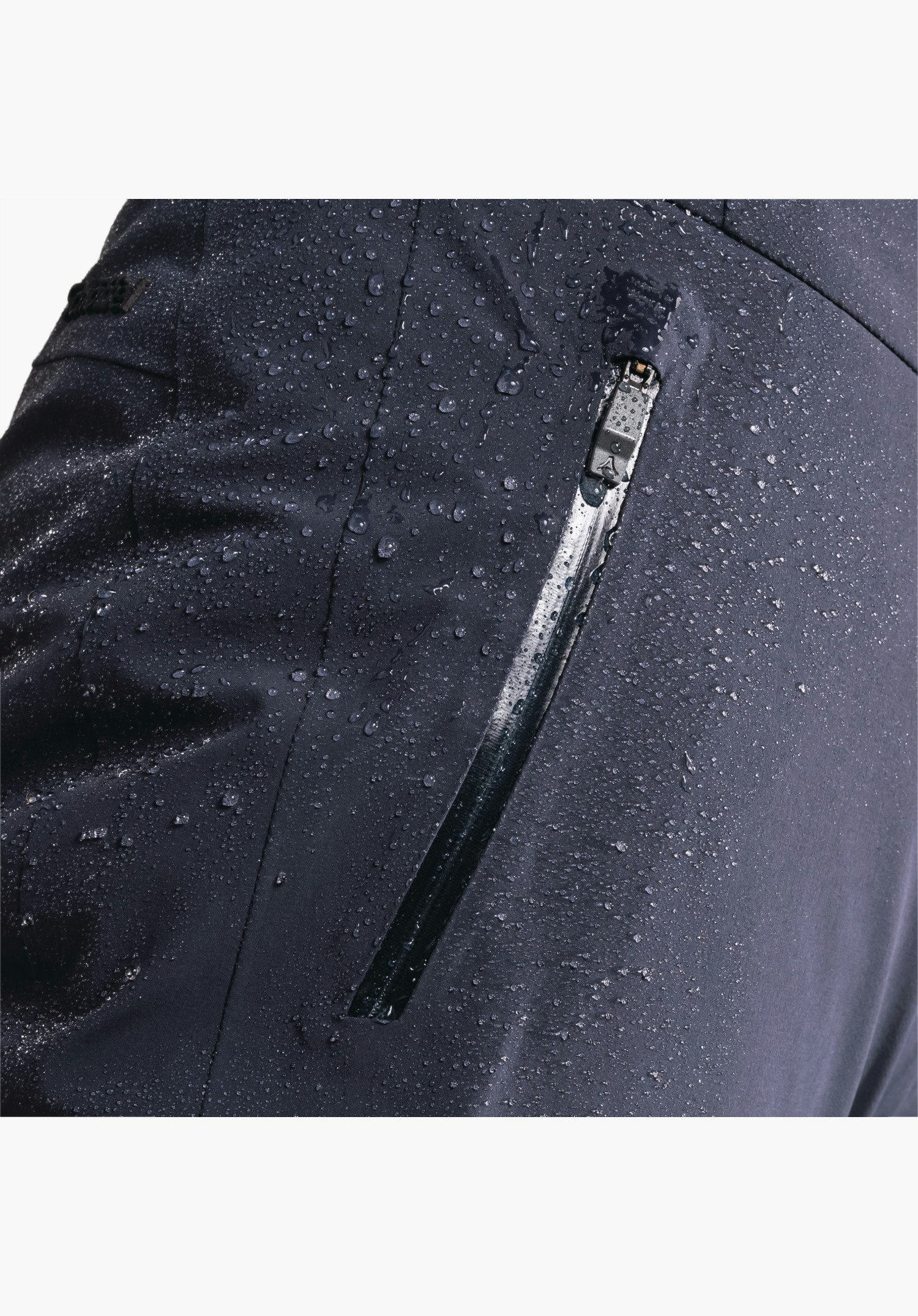 Pants Style Skayra WMS: De met waterdruppels bedekte blauwe stof toont een rits met Schöffel-logo op de trekker, close-up voor een witte achtergrond.