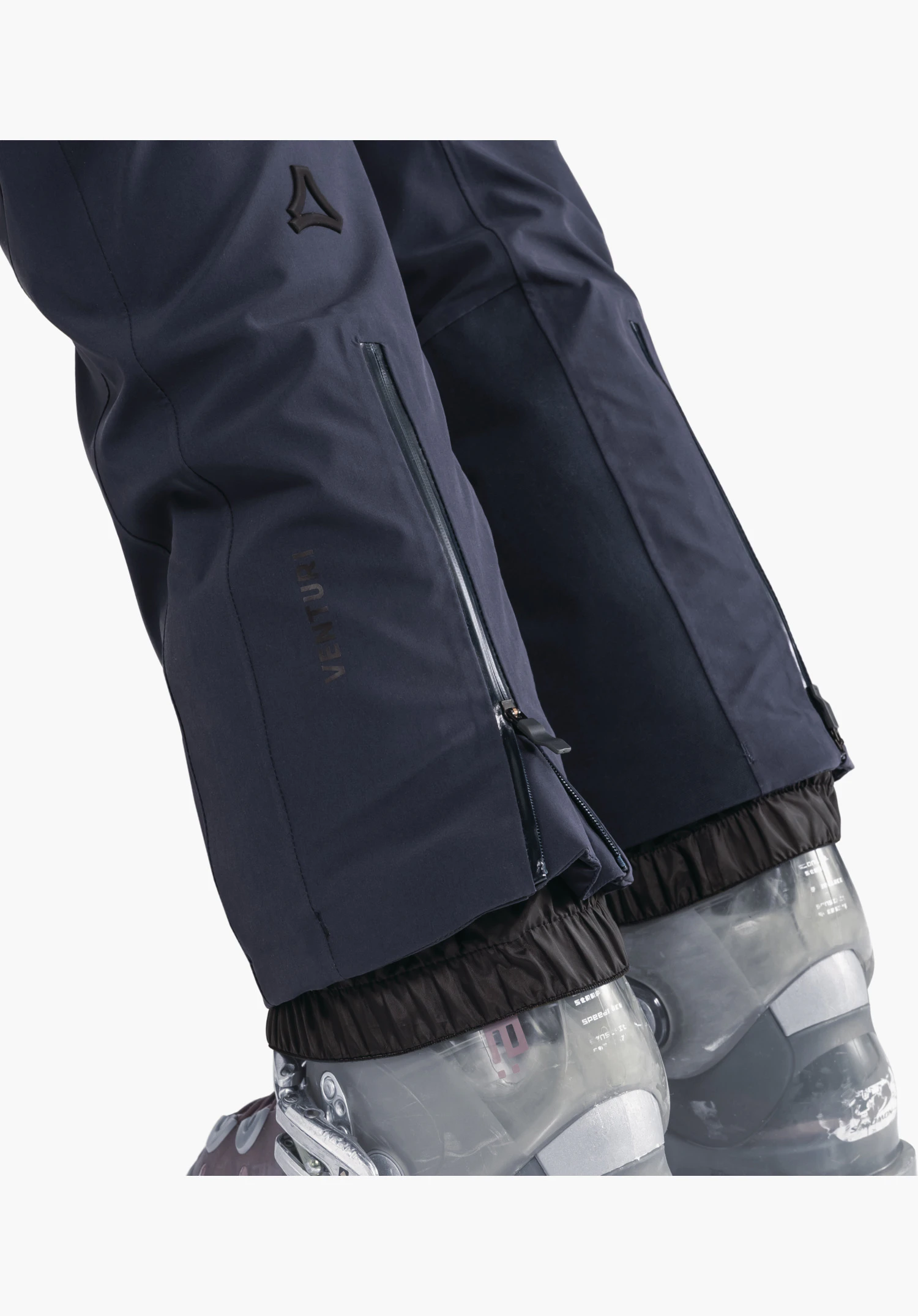 Pants Style Skayra WMS zeigt die blauen Beinabschlüsse mit seitlichen Reißverschlüssen, dem Venturi-Schriftzug und dem Schöffel-Logo über dem Schneefang als Nahaufnahme vor weißem/neutralem Hintergrund.