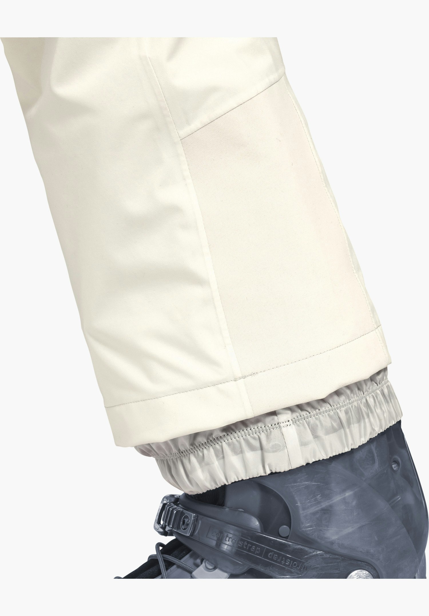Pants Style Pine WMS montre le bas de jambe en natur avec une protection des carres renforcée et une guêtre pare-neige élastique sur la chaussure de ski, gros plan sur fond blanc/neutre.