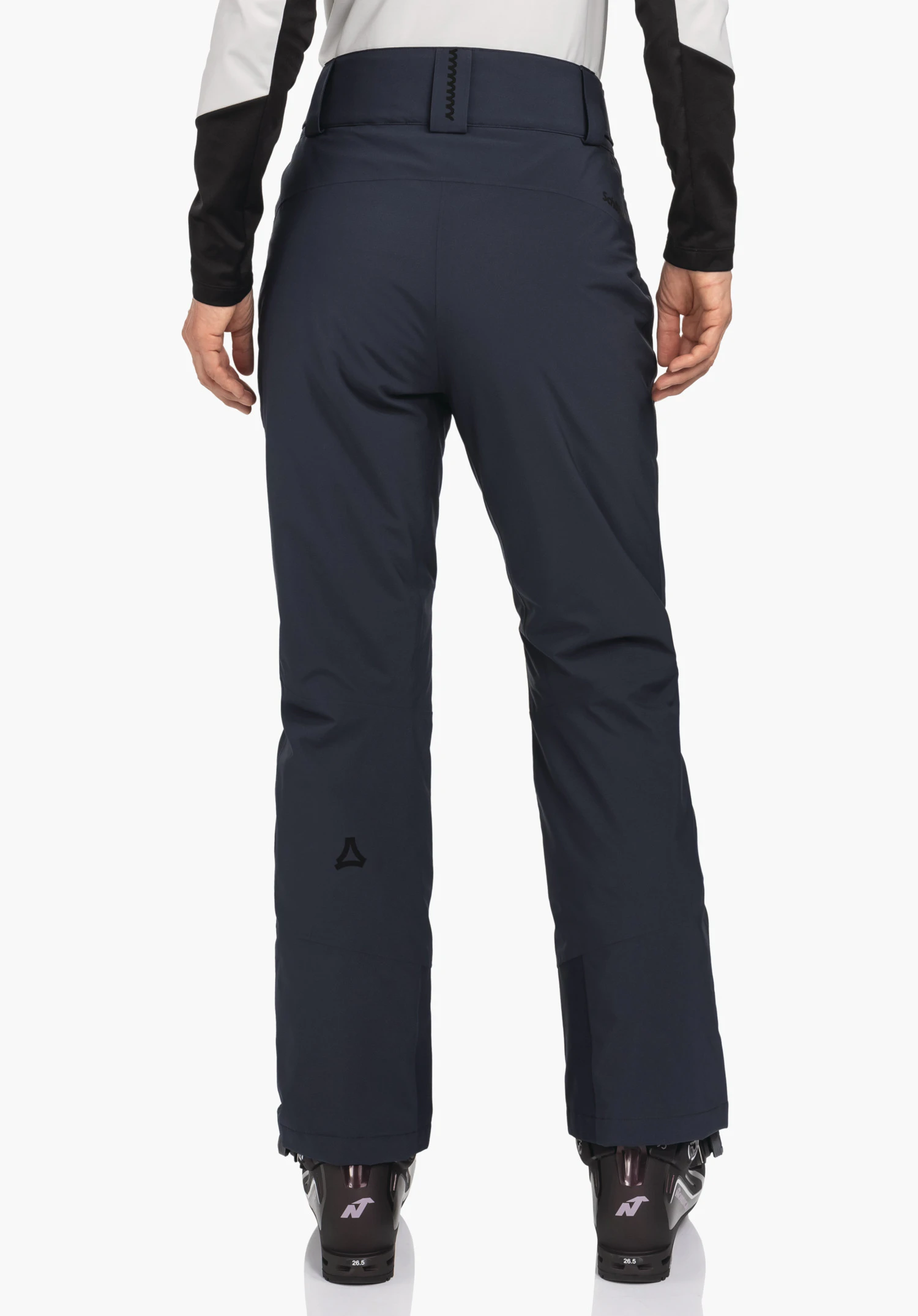 Pants Style Pine WMS donkerblauwe skihose, gedragen door een staande persoon met de rug naar de camera; handen langs het lichaam, zwarte skischoenen zichtbaar, Schöffel-logo op de kuit, witte achtergrond.