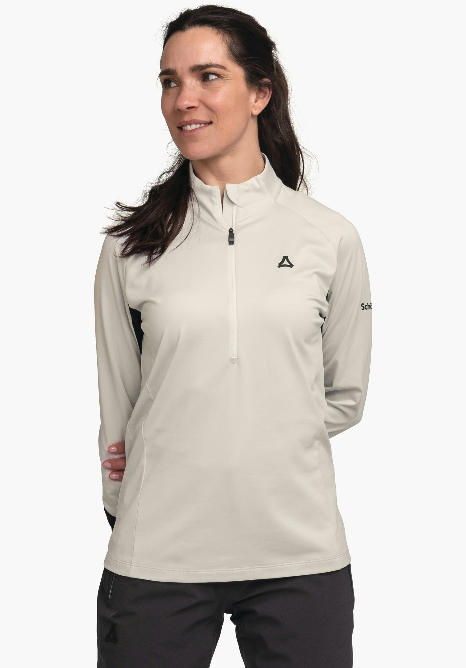 Longsleeve Style Safoon WMS haut manches longues gris clair avec fermeture éclair et logo Schöffel, porté par une femme souriante regardant de côté, mains derrière le dos, devant un fond blanc. Texte:"Schöffel".