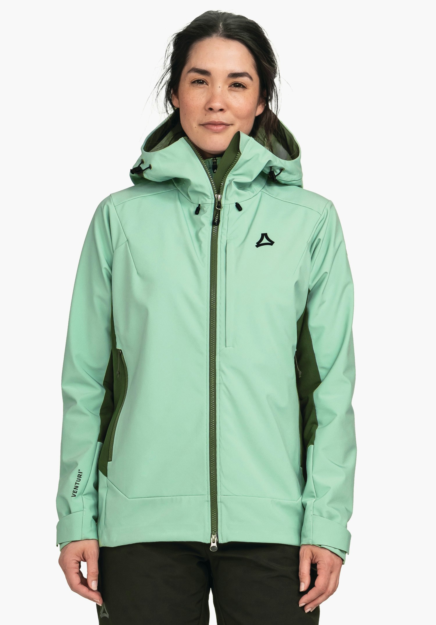 Softshell Jk Style Milagle WMS veste vert clair, portée par une femme debout de face, capuche relevée, empiècements vert foncé, logo Schöffel sur la poitrine, inscription "VENTURI" sur la manche gauche; fond blanc.