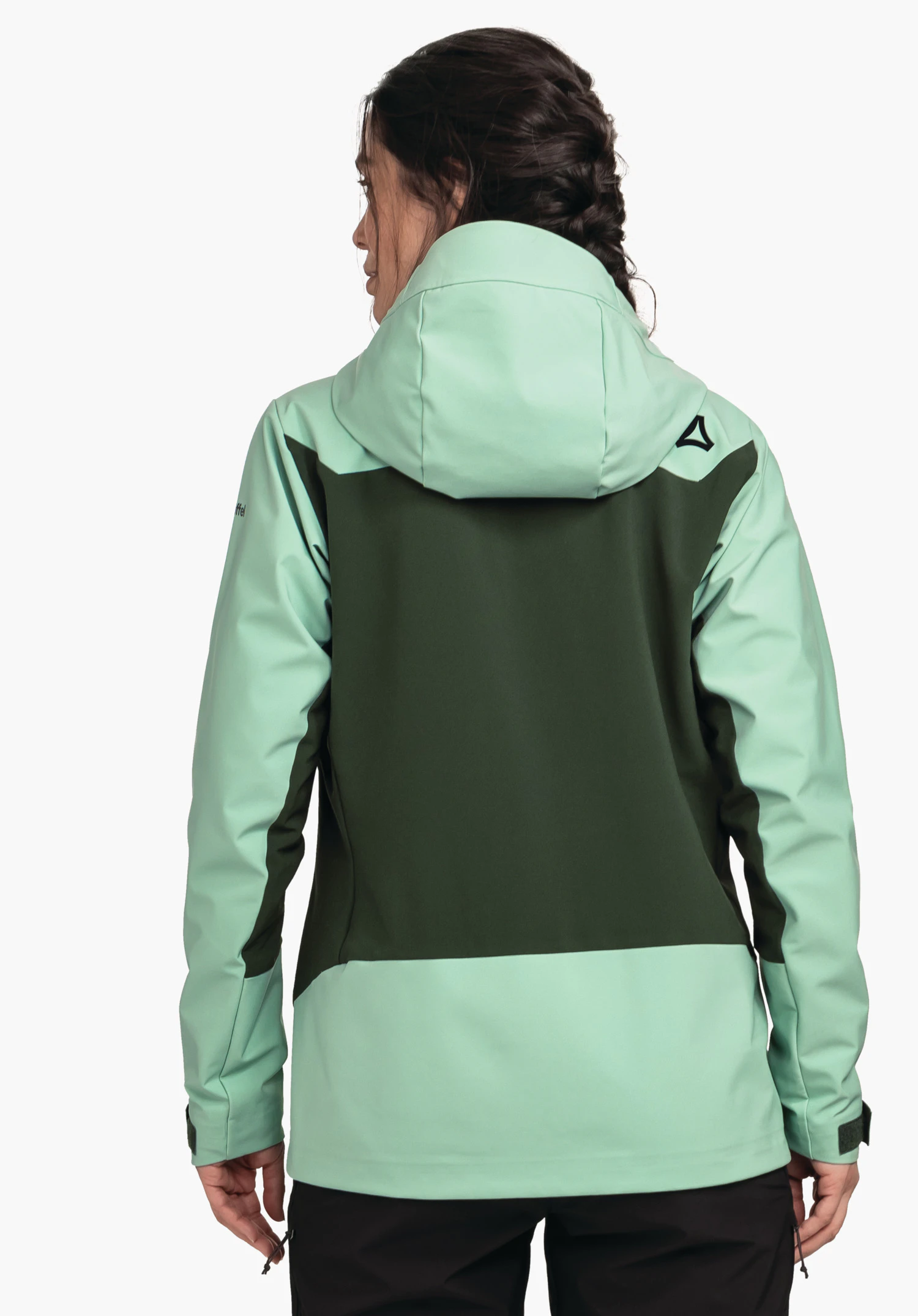 Softshell Jk Style Milagle WMS veste femme vert clair et vert foncé à capuche, portée de dos; personne debout dos à la caméra; logo Schöffel sur l’épaule droite; fond blanc neutre.