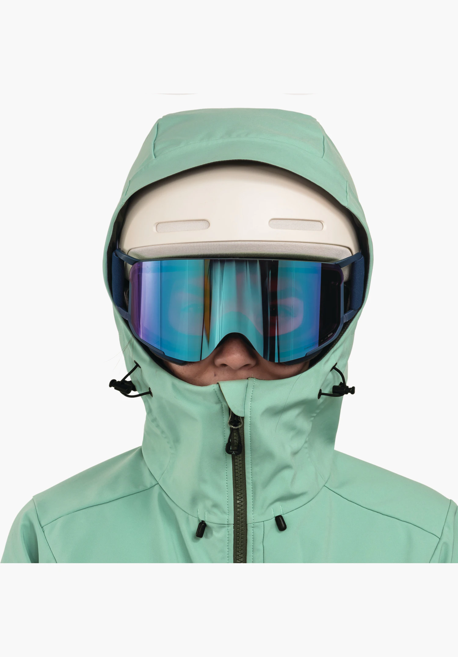 Softshell Jk Style Milagle WMS montre la capuche compatible avec un casque et le col haut en vert, portés avec un casque et un masque de ski, gros plan sur fond blanc/neutre.