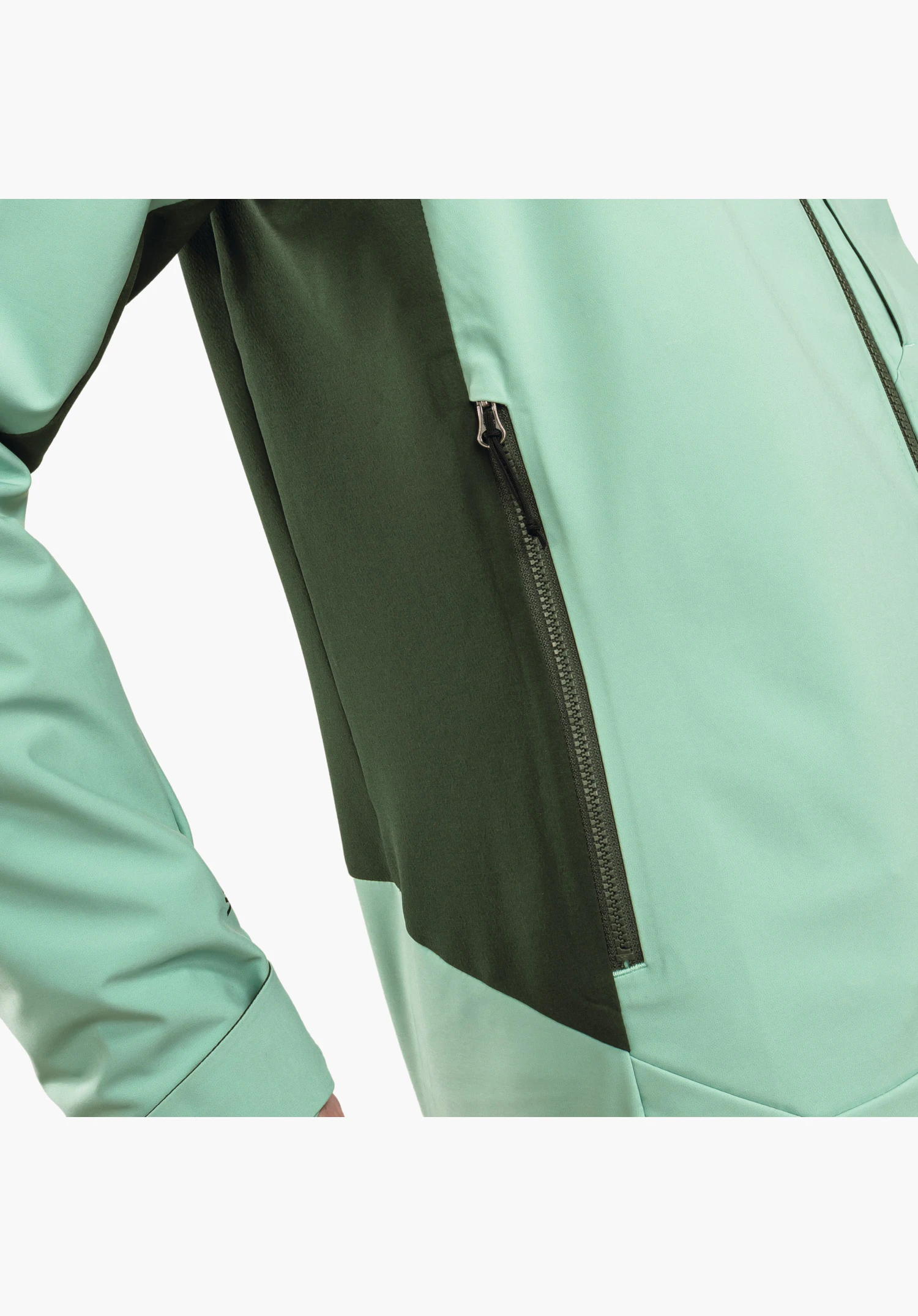 Softshell Jk Style Milagle WMS avec un focus sur la poche zippée latérale intégrée dans un empiècement vert foncé qui contraste avec la nuance de vert plus clair du tissu softshell, gros plan sur fond blanc.