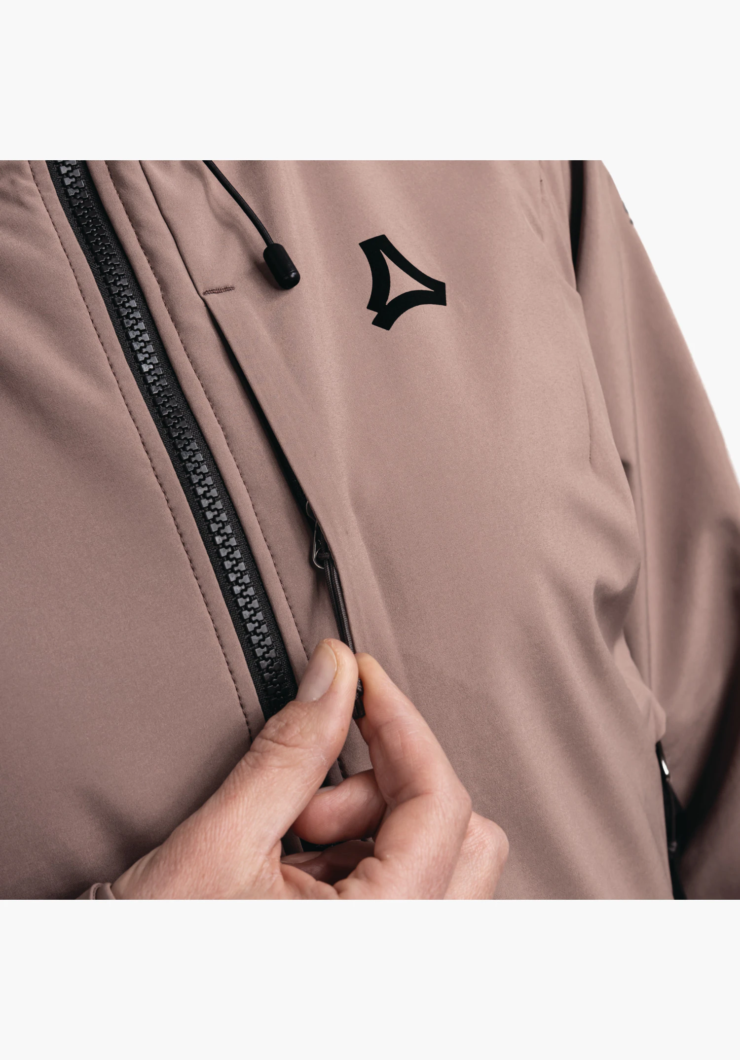 Softshell Jk Style Milagle WMS, vue détaillée de la fermeture éclair noire et du logo Schöffel noir sur la matière softshell lila, avec une main manipulant le curseur, gros plan sur fond blanc/neutre.