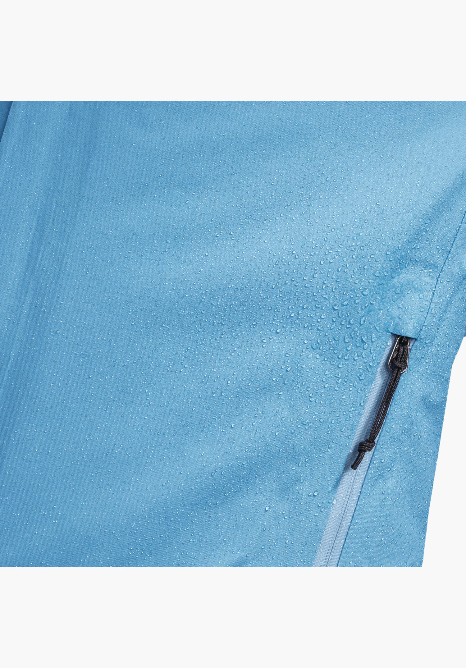Jacket Style Milagle WMS zeigt die wasserabweisende Oberfläche des blauen Stoffs mit abperlenden Wassertropfen und einen Reißverschluss mit Kordelzug als Nahaufnahme vor weißem Hintergrund.