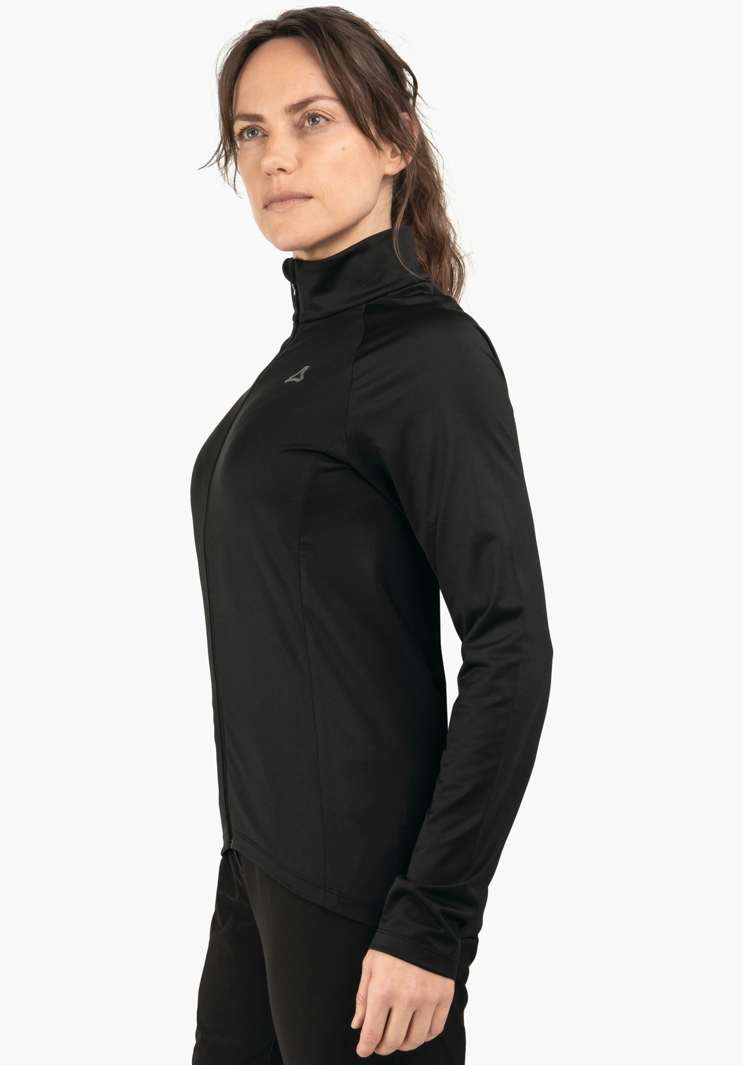 Longsleeve Style Kubena WMS Frau trägt schwarze Jacke mit Schöffel-Logo, steht im Profil und blickt leicht nach oben; rechter Arm entspannt, vor einheitlichem weißem Hintergrund.