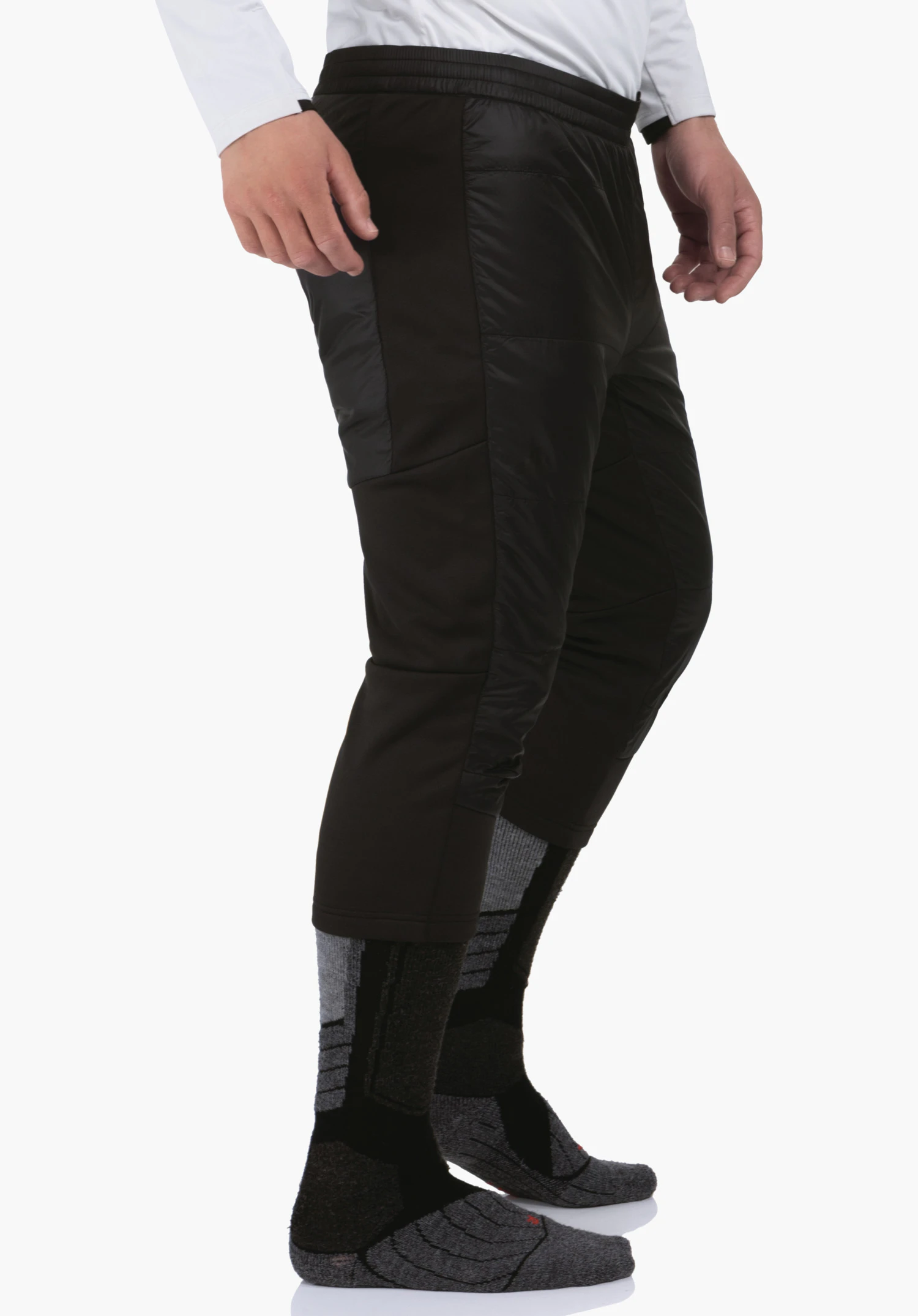3/4 Pants Style Lufillo MNS black padded 3/4-length trousers, standing side-on on a white background; slightly bent leg, visible hands, grey and black sports socks, white top.