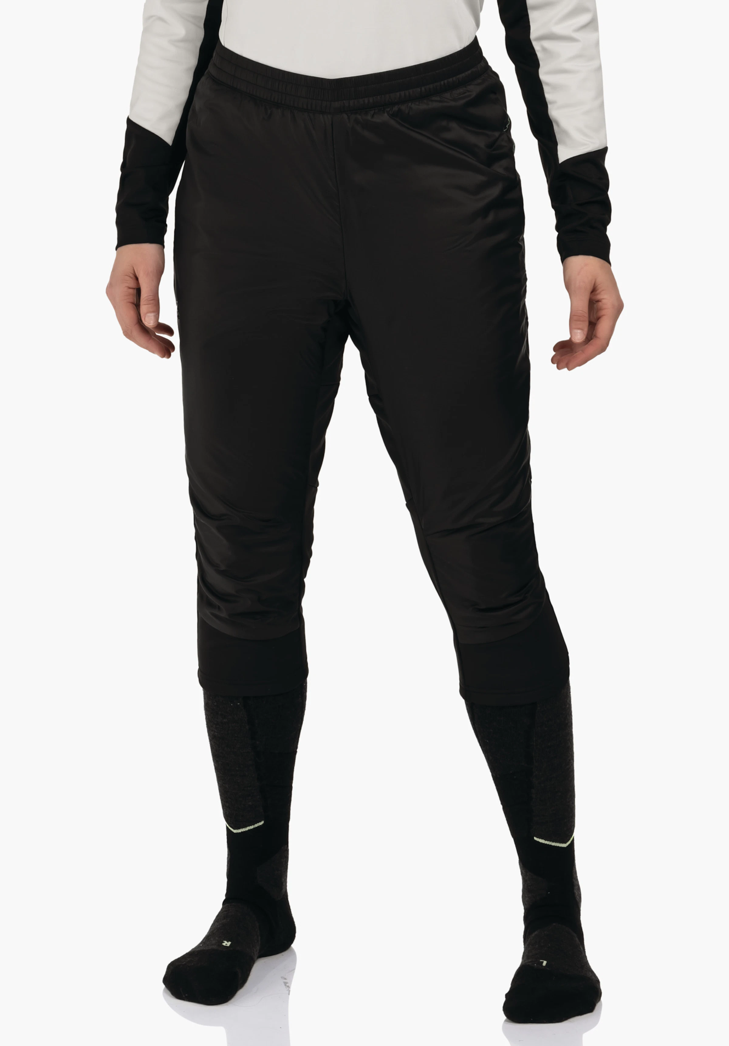 3/4 Pants Style Lufillo WMS pantalon thermique noir longueur mollet, porté par une personne debout, coupe ample à la taille et aux cuisses; contexte:t-shirt blanc, chaussettes de sport gris foncé, fond blanc.
