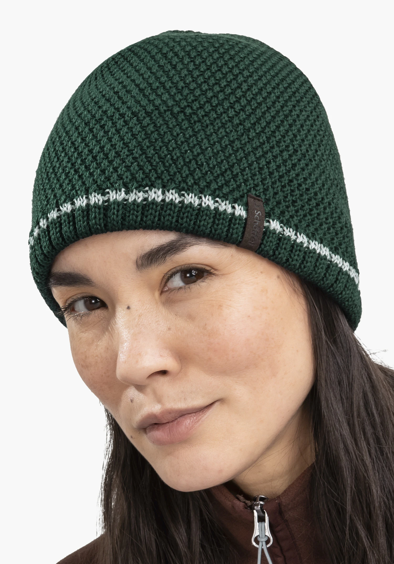 Hat Style Wildkar ALL Dark green, chunky knitted beanie sits on the head; worn by a woman with dark hair against a white background. Text on tag: Schöffel.