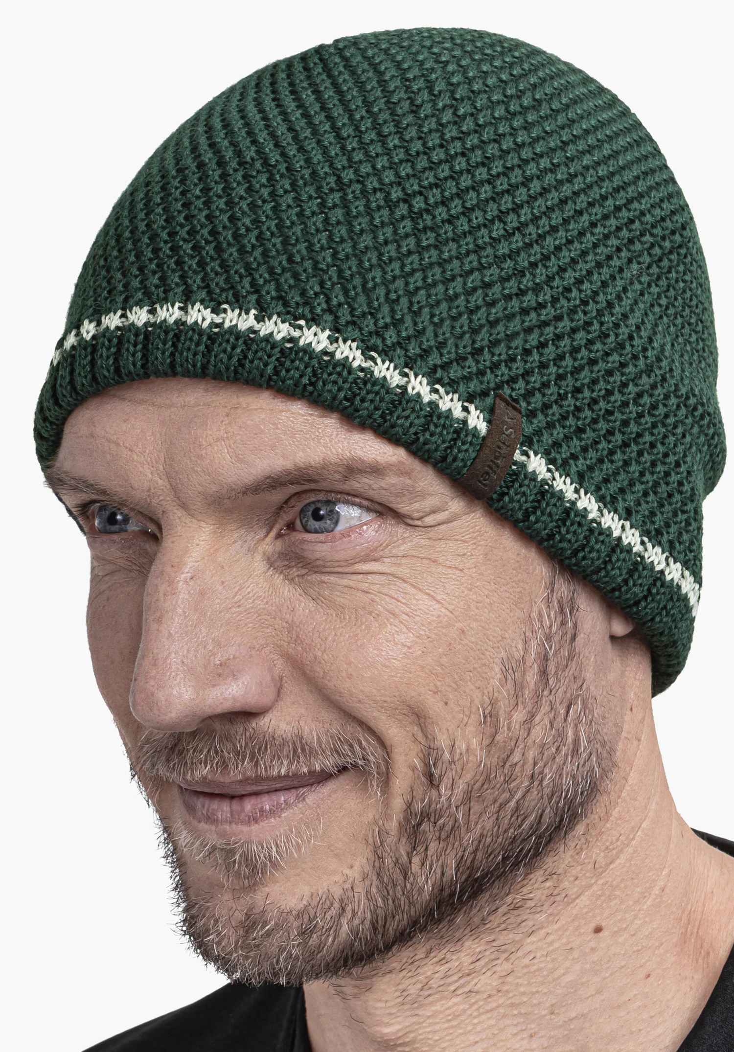 Hat Style Wildkar ALL dark green knitted beanie with a white stripe worn by a person; chunky knit, brown label with “Schöffel” lettering; face with short beard; light background.